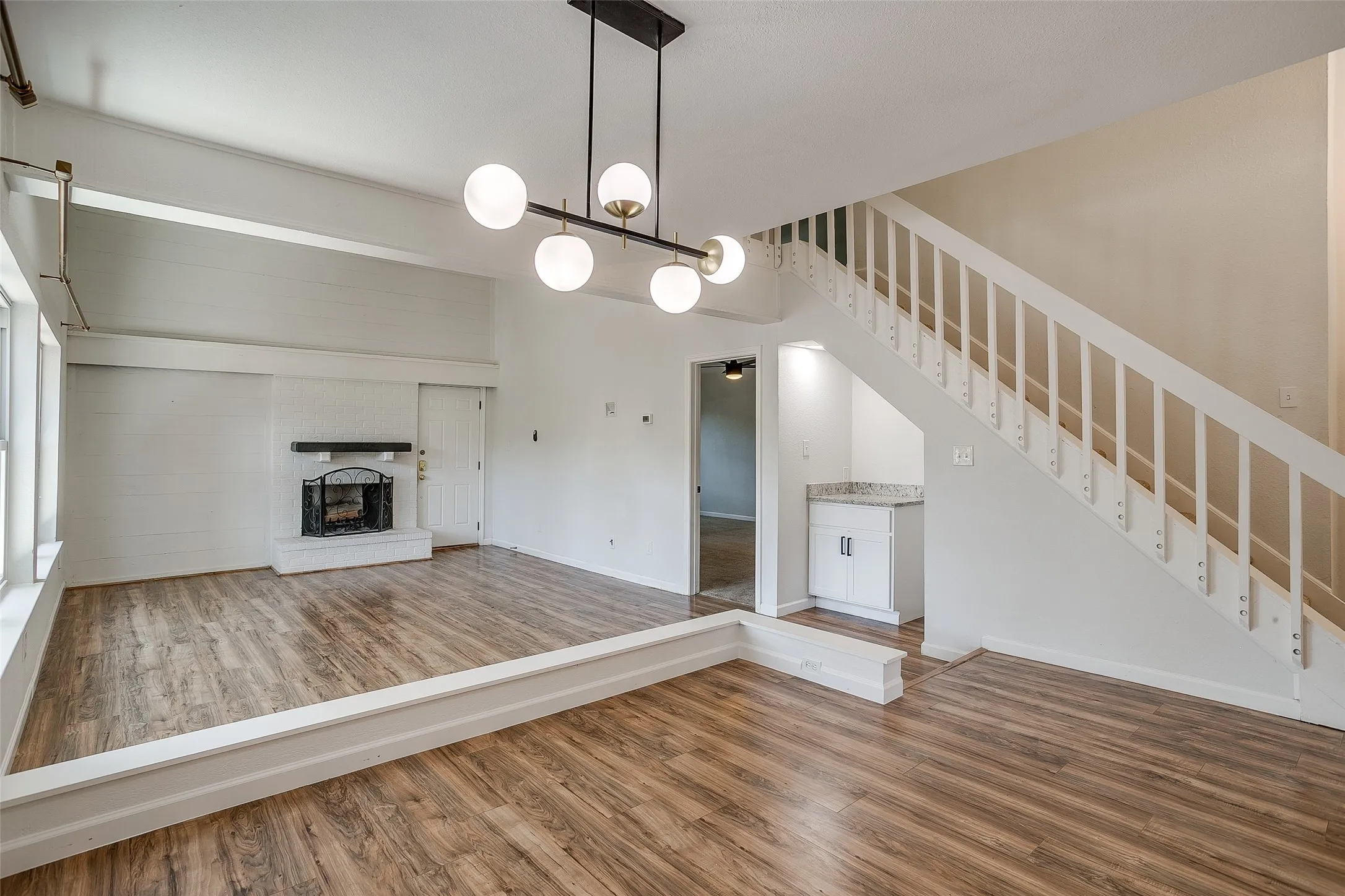 Open-concept great room with vaulted ceilings and staircase.