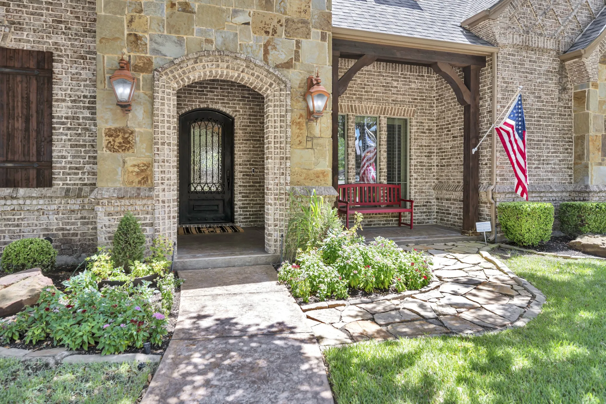 Lovely, Covered Front Porch Sitting with Impressive Iron Front Door.