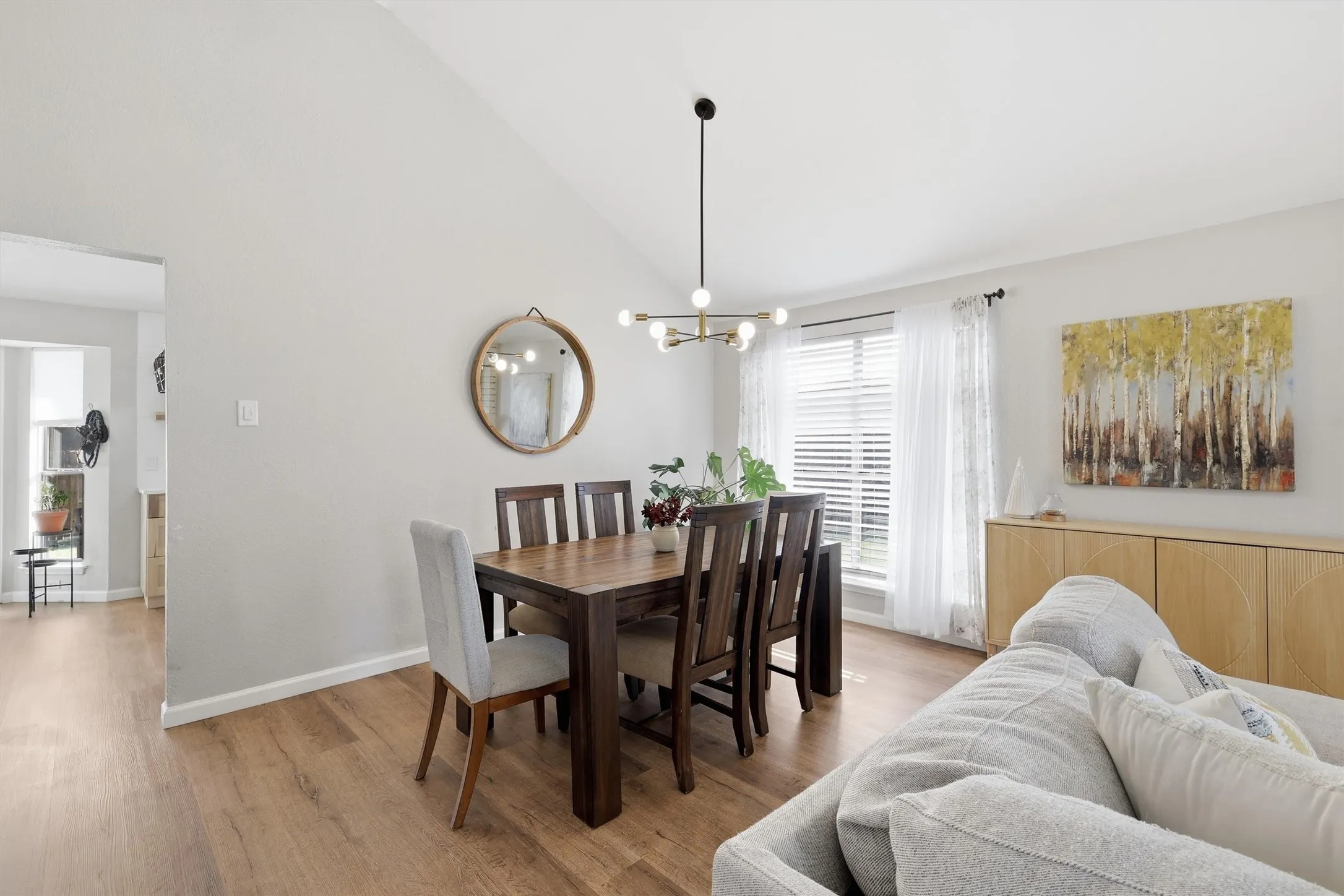 Vaulted ceiling over a dining area with wood-finish flooring
