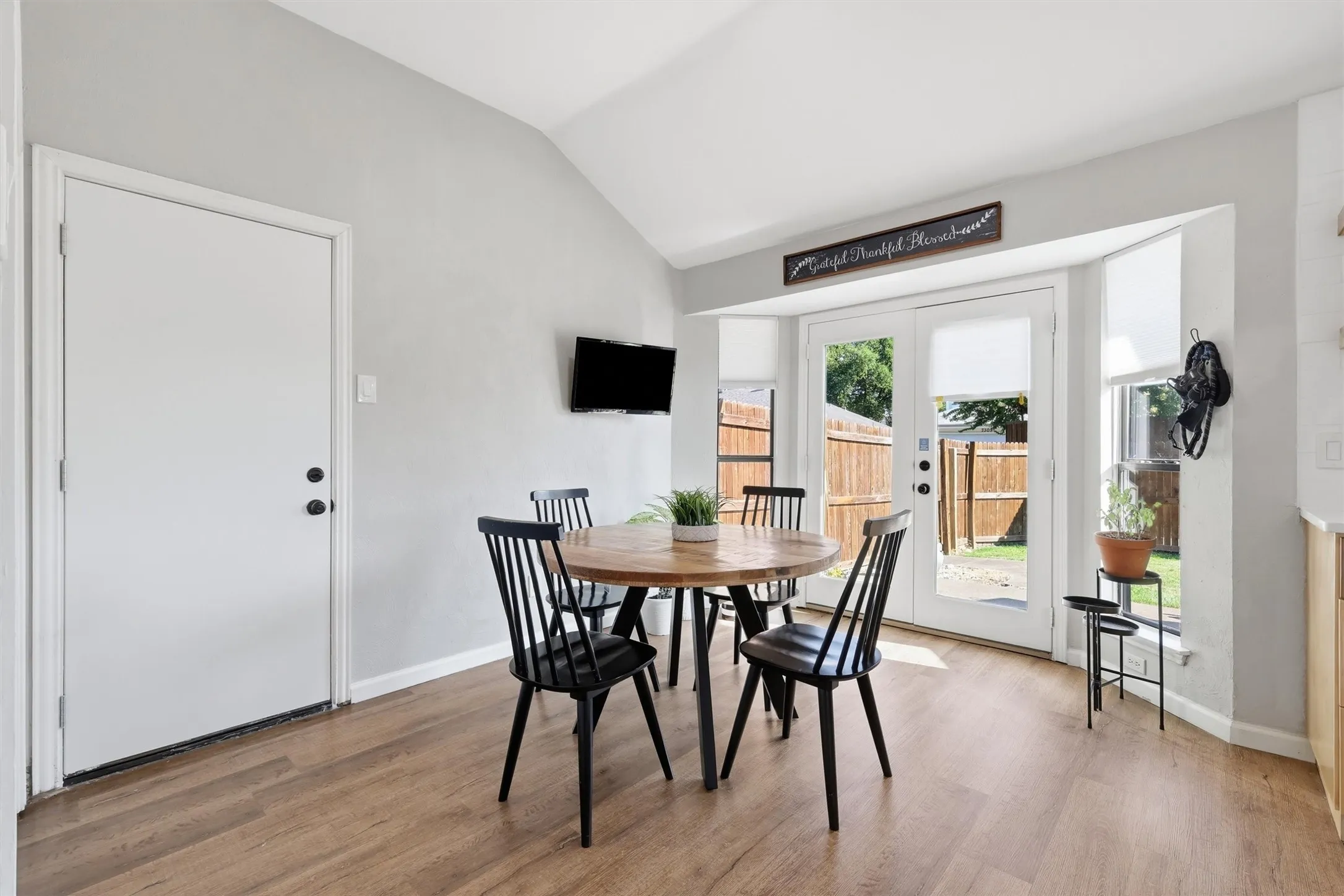 Dining area with wood-finish flooring and a vaulted ceiling