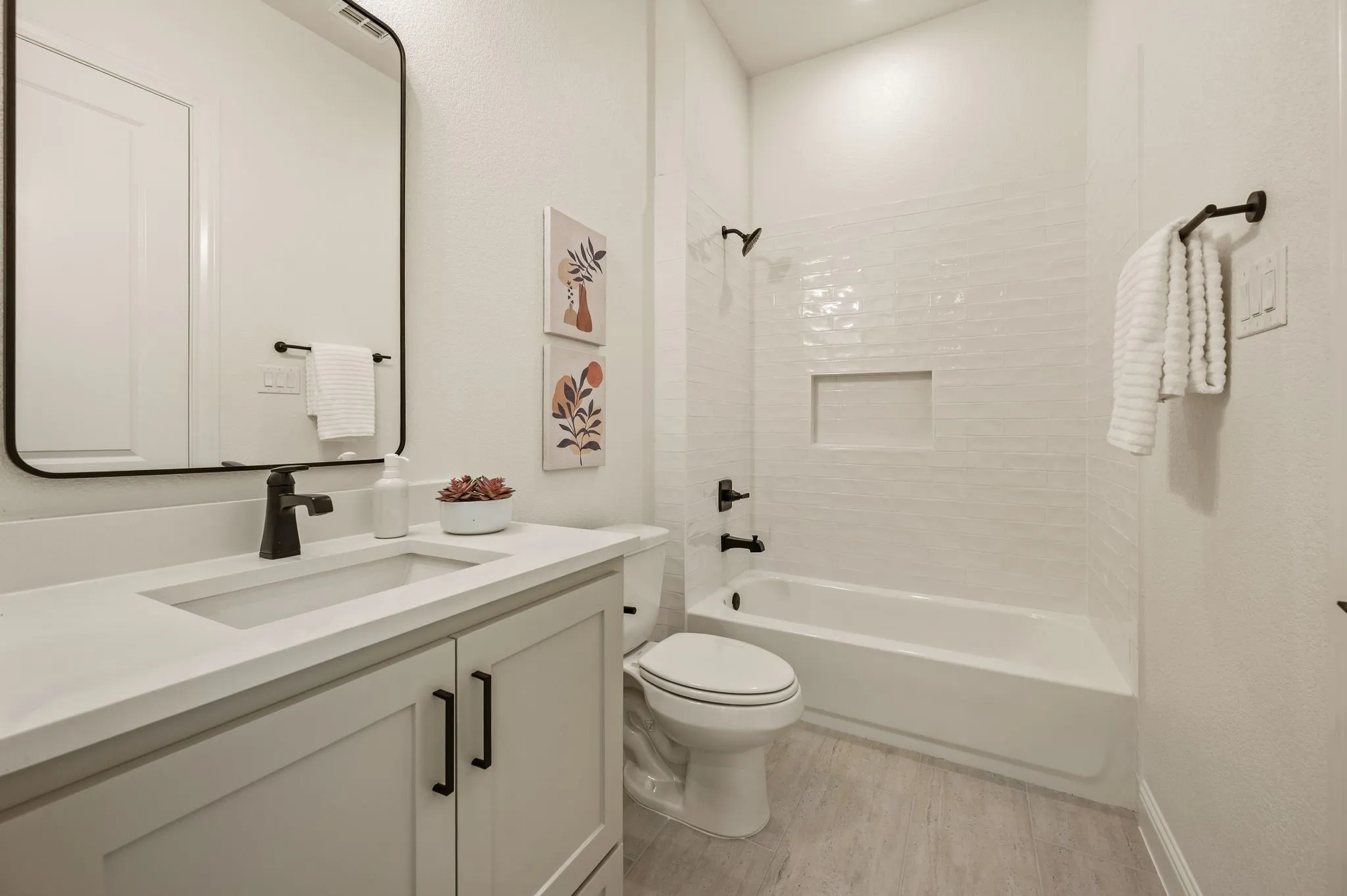 Bathroom featuring a single vanity with light cabinetry, a rectangular undermount sink, and a light-toned countertop