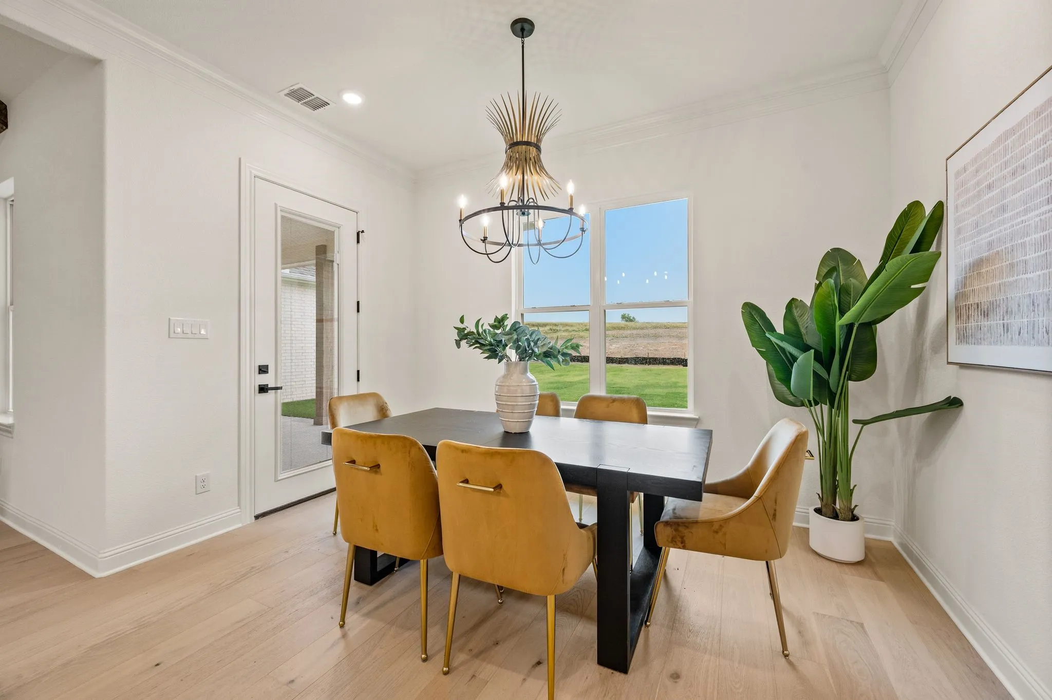 Dining area featuring light wood-finish flooring, white walls, and crown molding