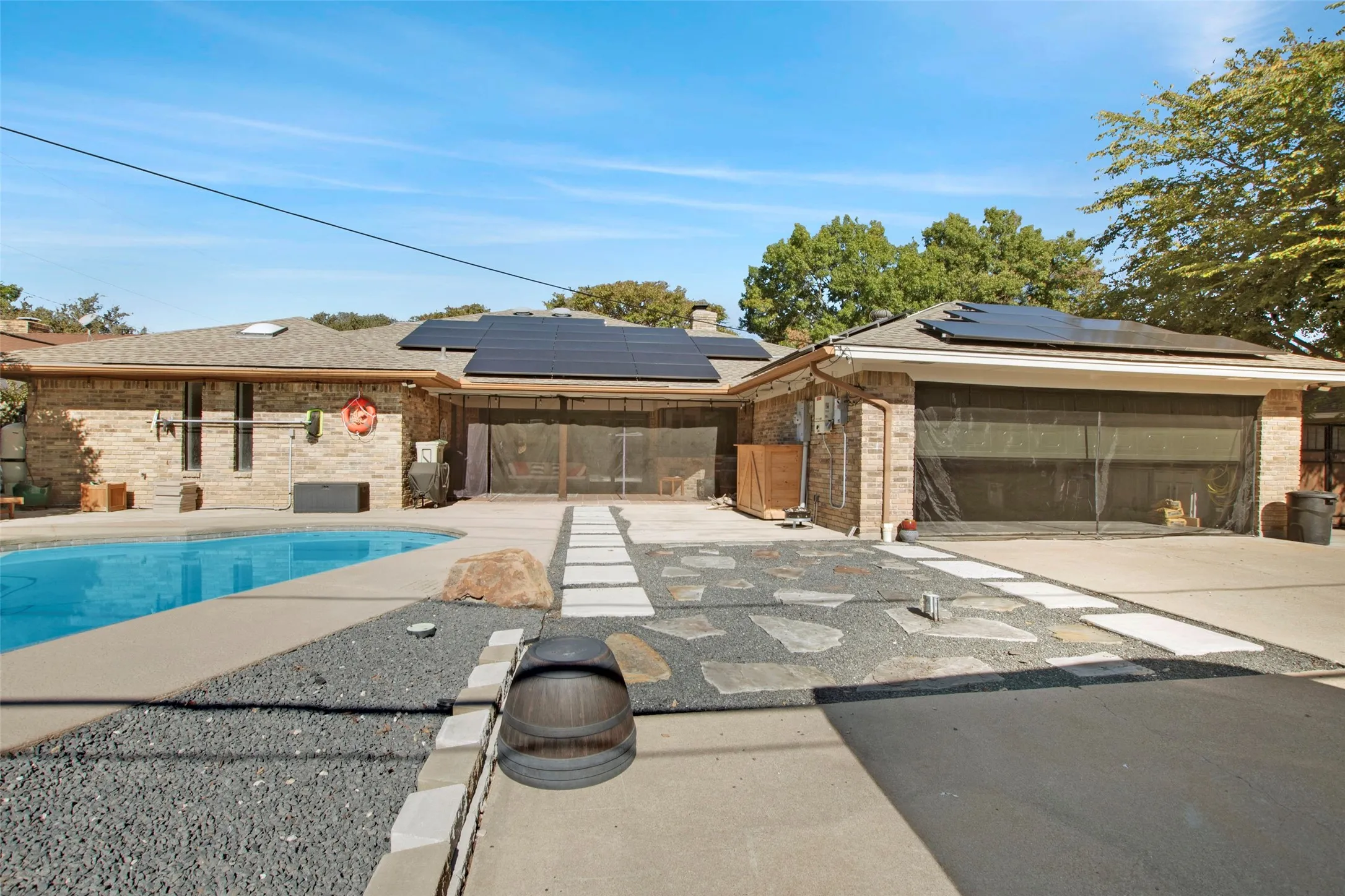 View of swimming pool with a sunroom and a patio area