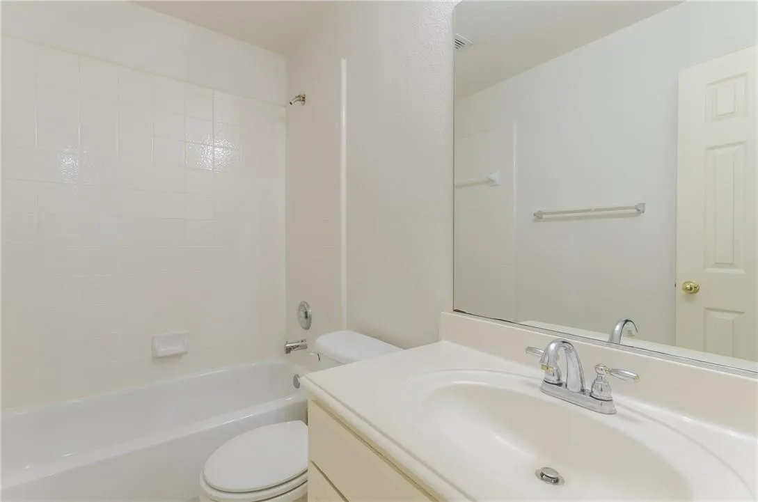 Bathroom featuring a built-in tub and shower combination with white tile surround