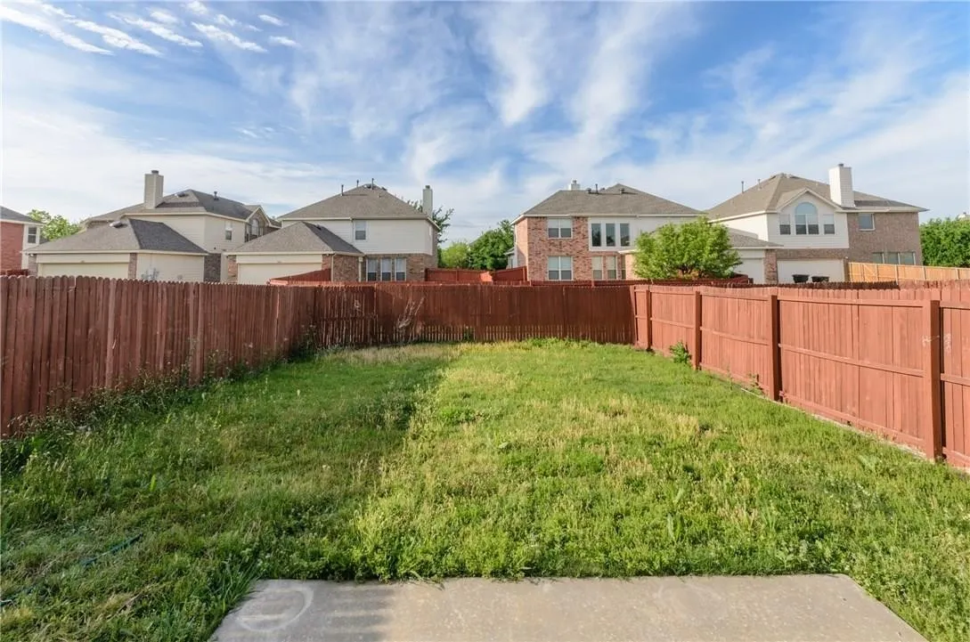 Fenced backyard with a concrete patio pad and perimeter fencing