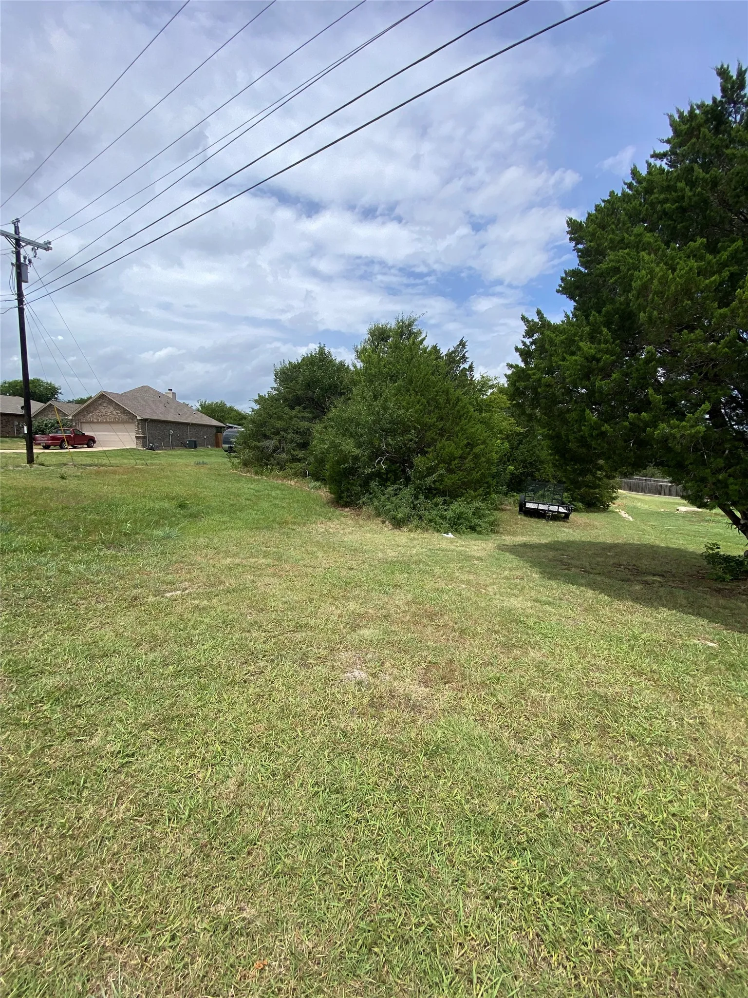 Expansive grassy terrain featuring mature trees providing natural screening