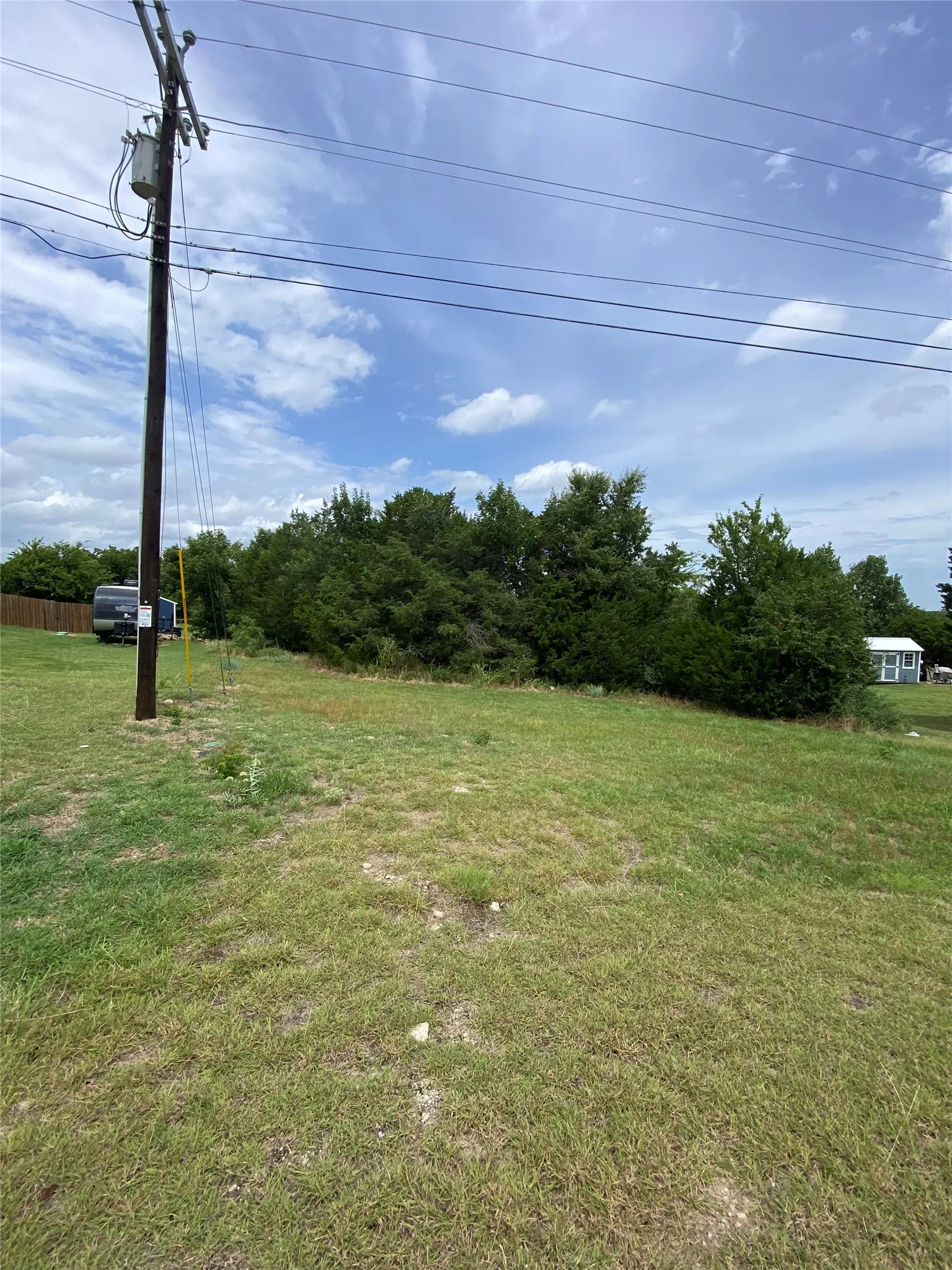 Expansive cleared land parcel with mature trees at the rear boundary