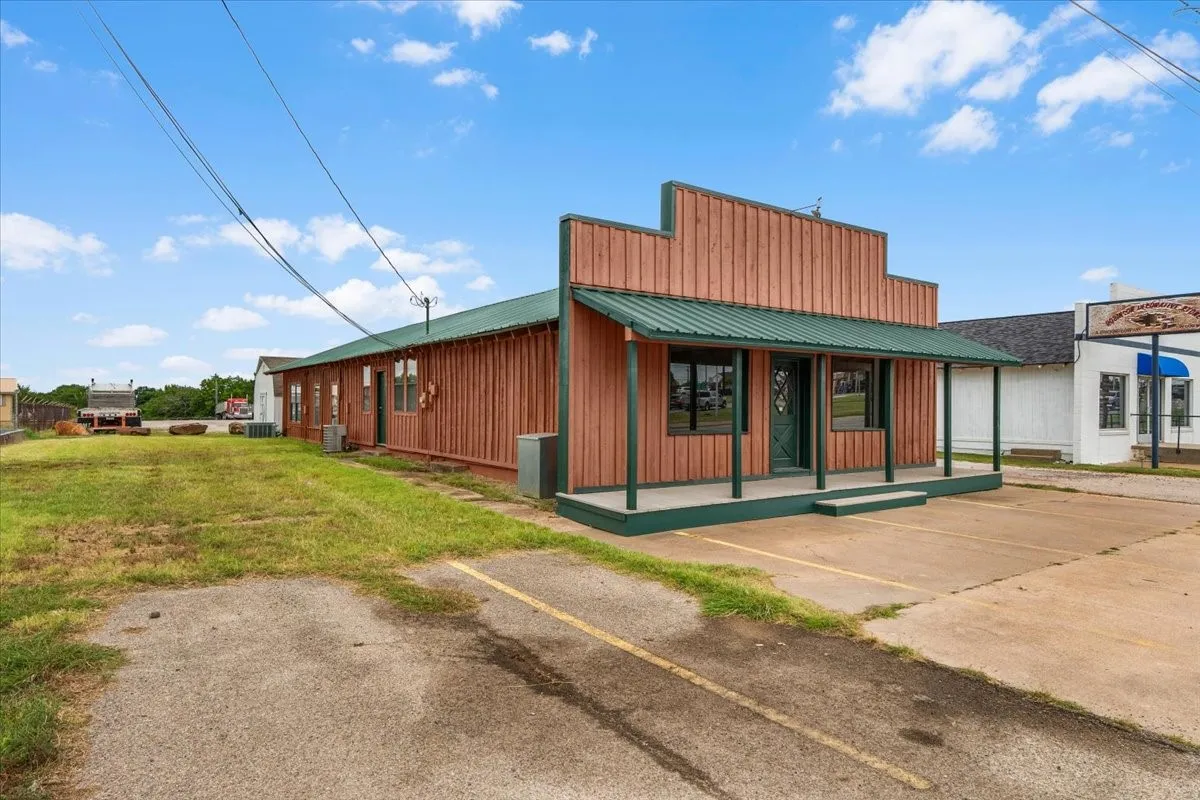 Commercial building featuring a prominent storefront with a green metal awning, and a wood-paneled exterior