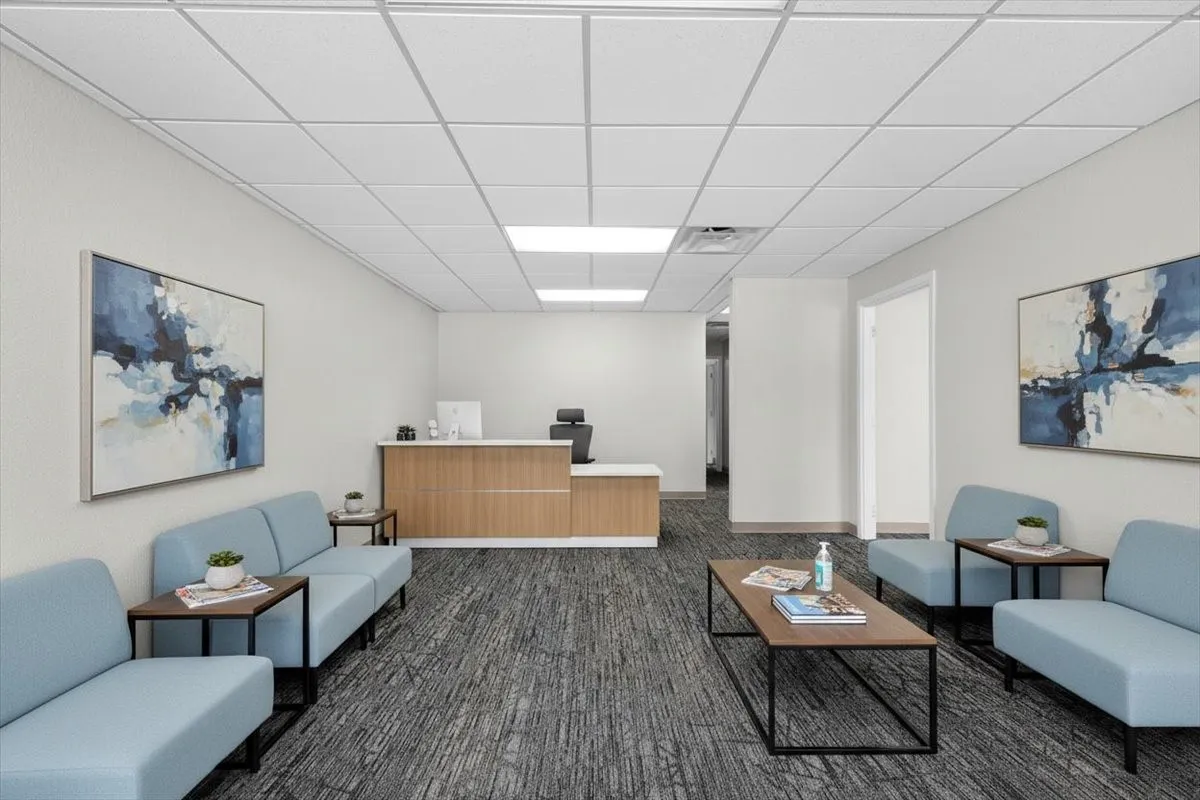 Reception area featuring a wood-finish and white countertop desk, recessed lighting, drop ceiling, and patterned carpet flooring