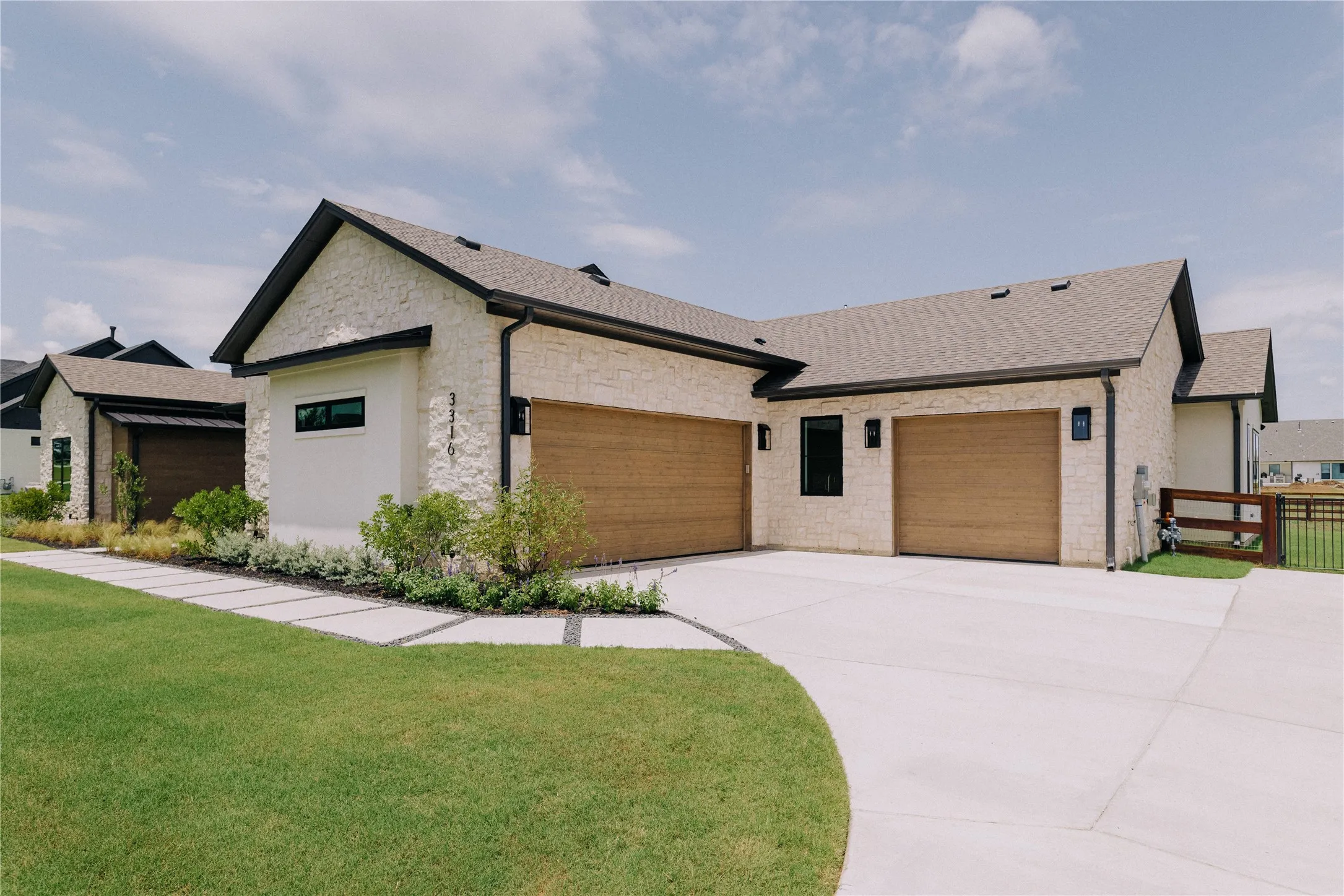 Modern two-story residence featuring a light stone and siding exterior with multiple gabled rooflines and architectural interest