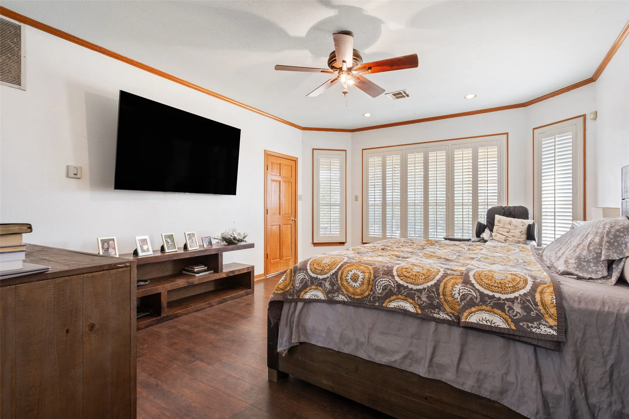 Spacious room with dark wood-finish flooring, white walls, and warm wood trim