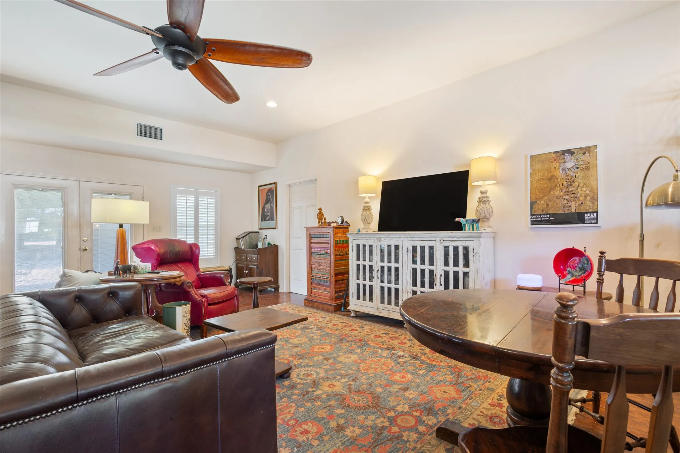 Spacious living area featuring wood-finish flooring, a ceiling fan, recessed lighting, and white walls