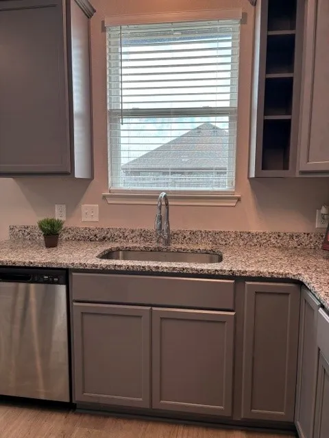 Stainless sink and dishwasher overlook backyard