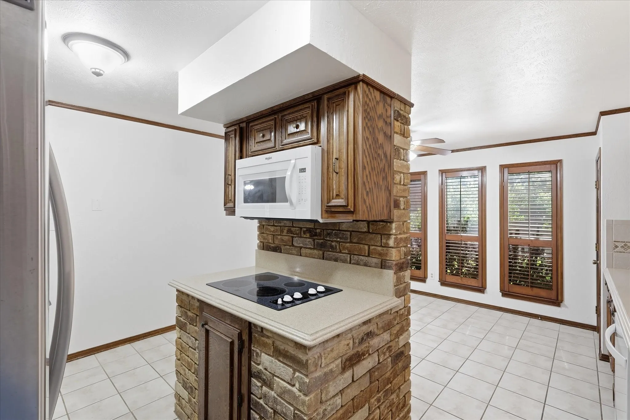 Electric cooktop and accent brickwork complete this unique kitchen.