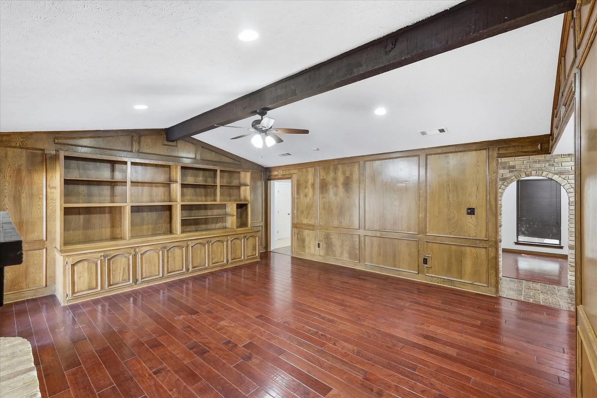 The living room offers warm wood paneling and a large wet bar.