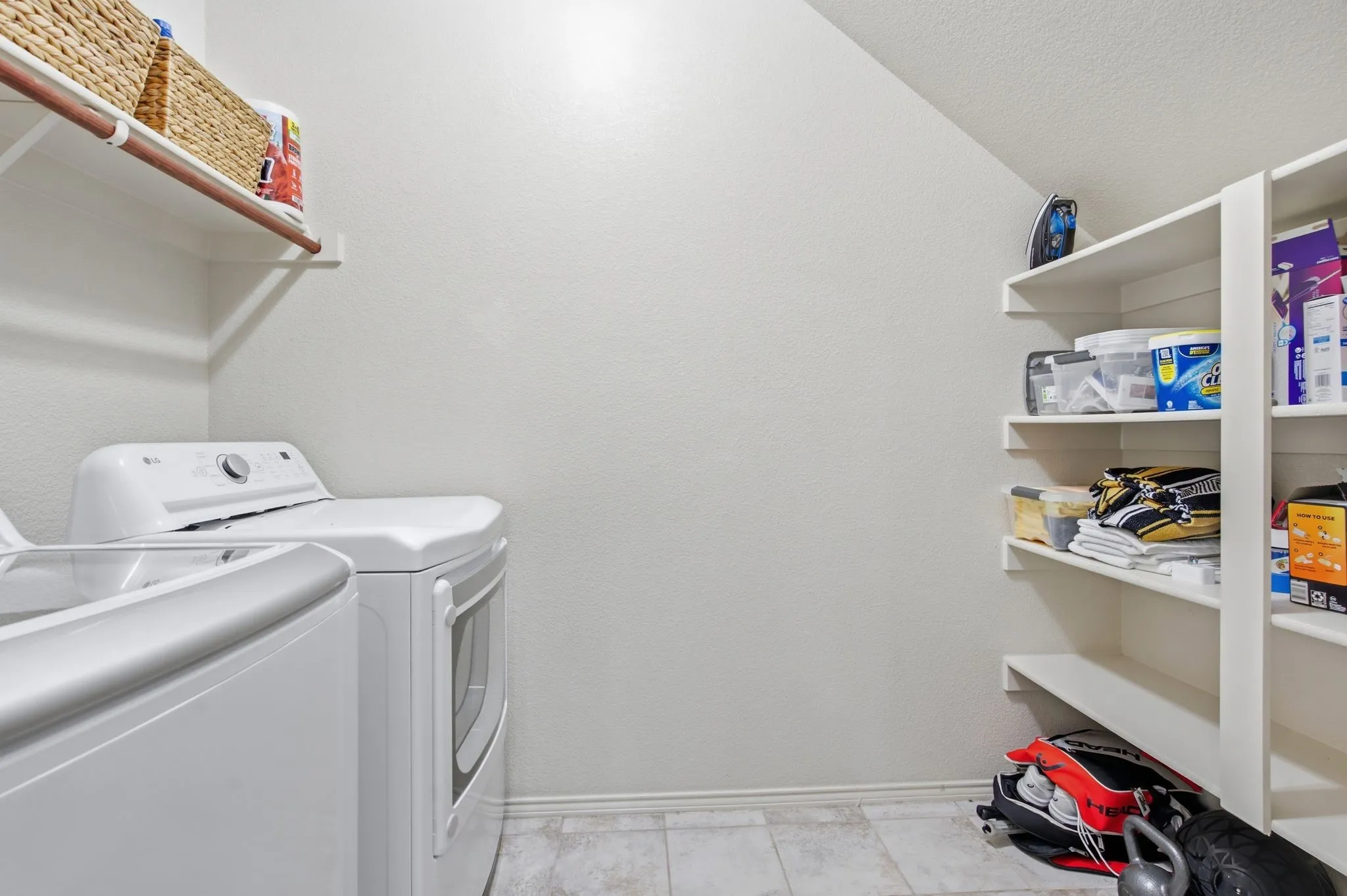downtairs laundry with shelving for loads of storage