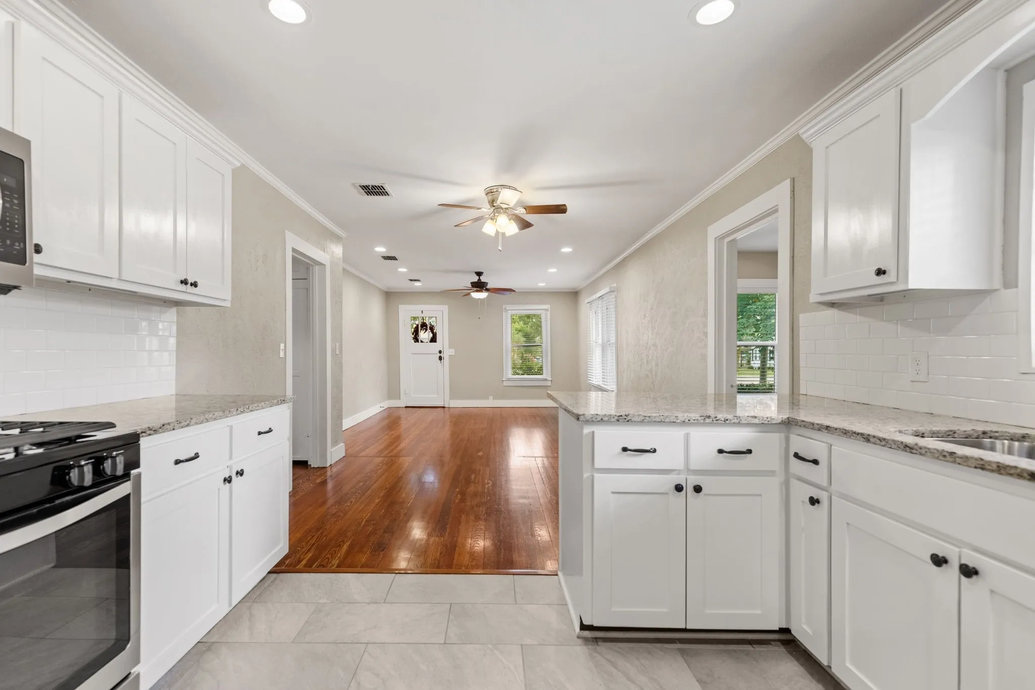 Contemporary kitchen with white cabinetry and granite countertops