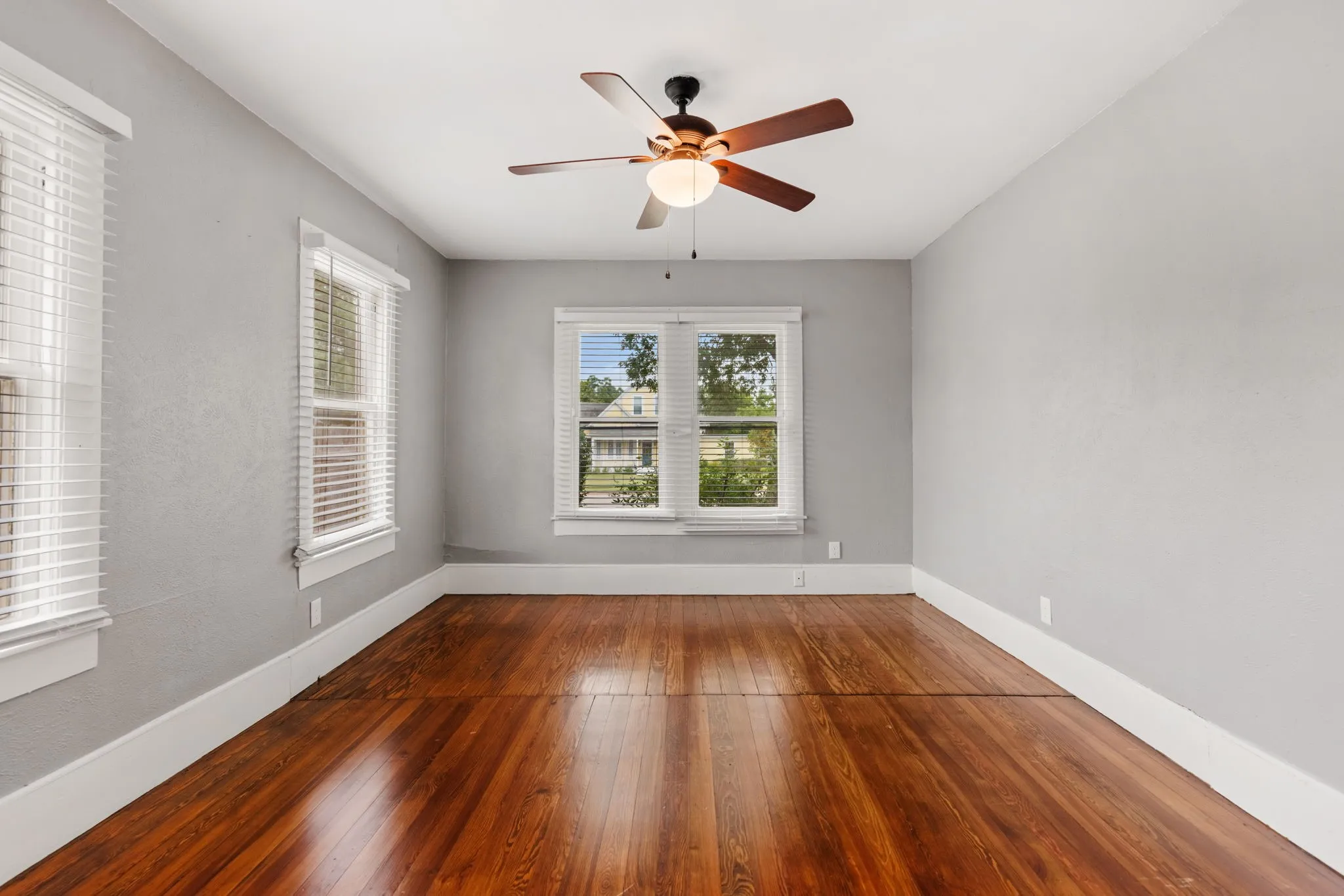 Bright interior space featuring rich wood-finish flooring, light gray walls, and white trim