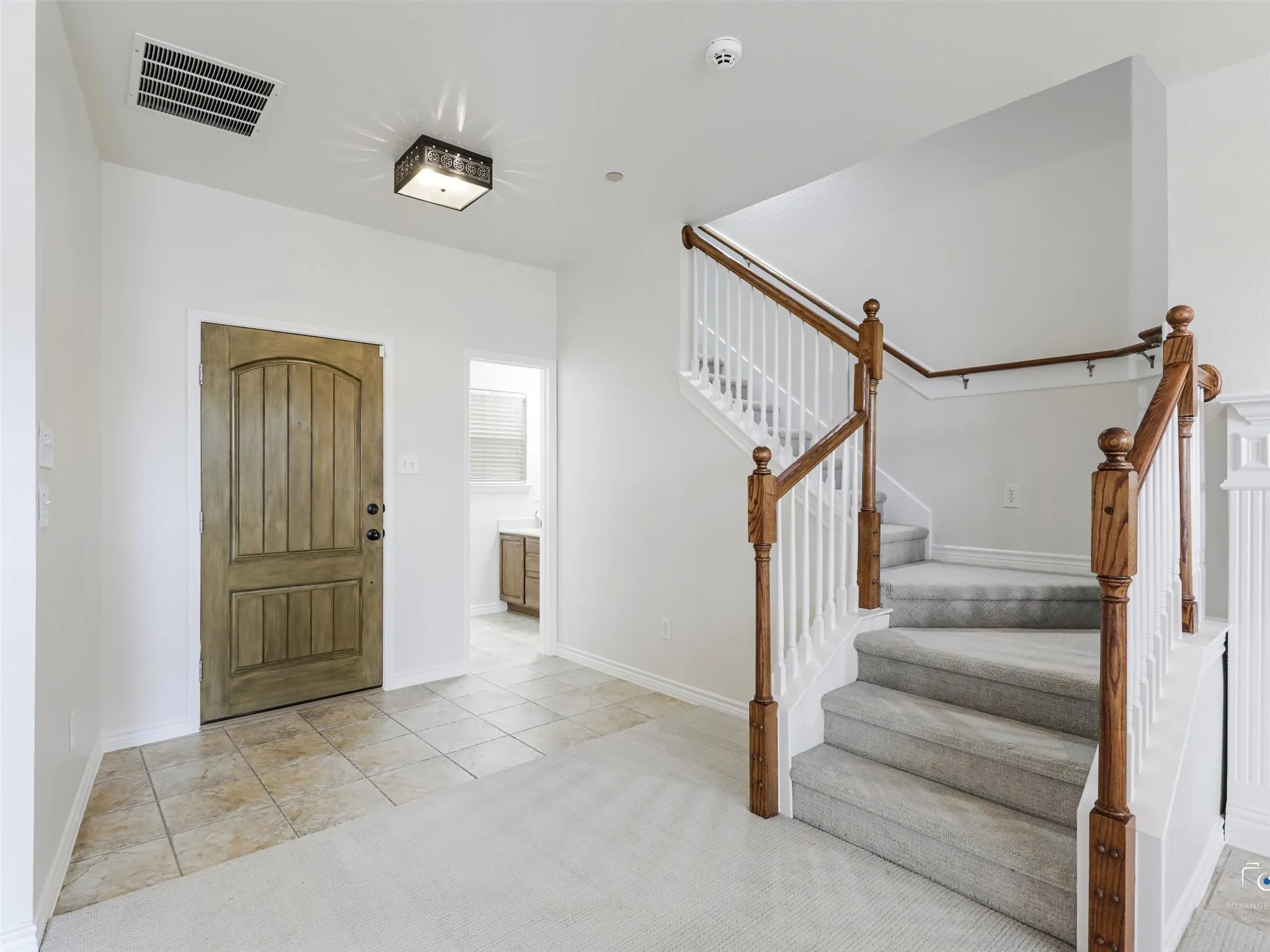 Entryway featuring a natural wood-finish door with an arched top panel