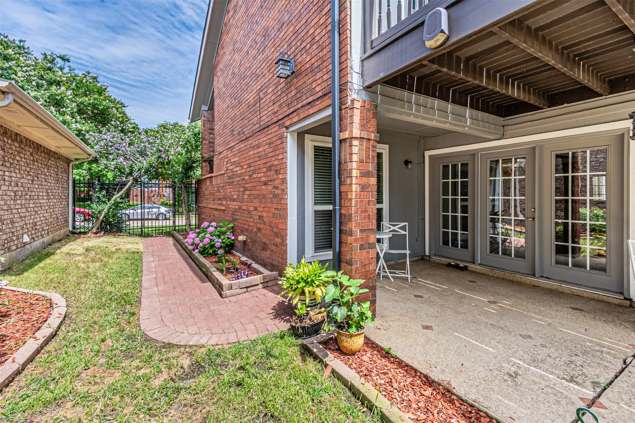 Ground-level patio with double French doors and brick exterior