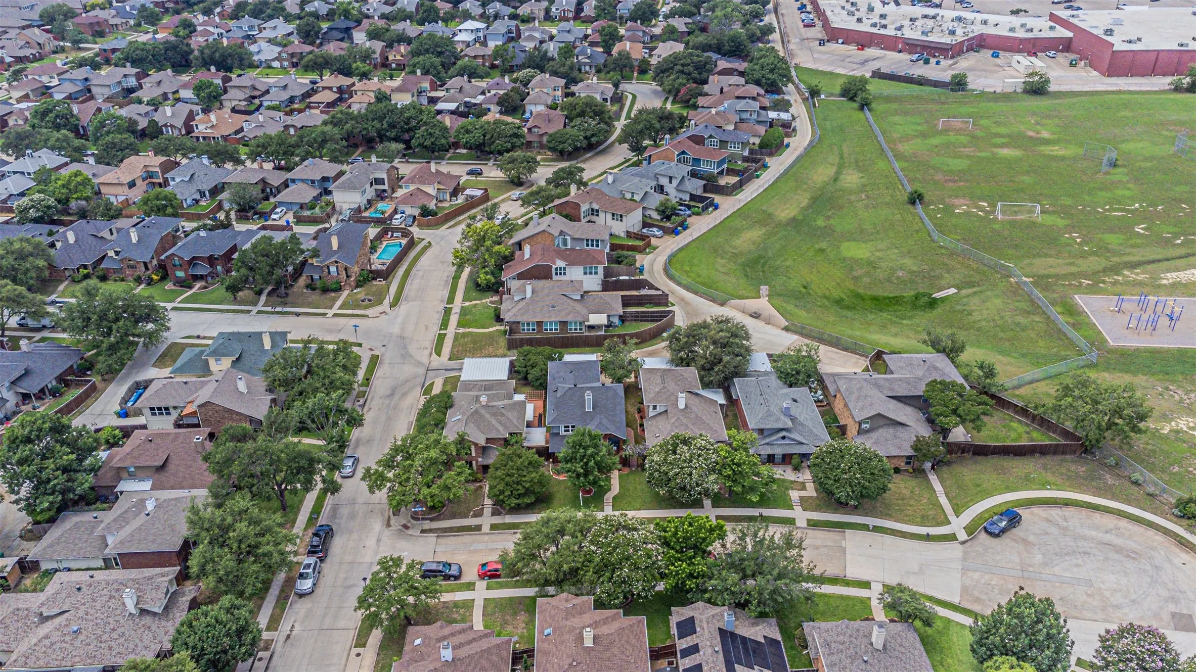 Aerial perspective showcasing a residential neighborhood with varied architectural styles and established tree canopy
