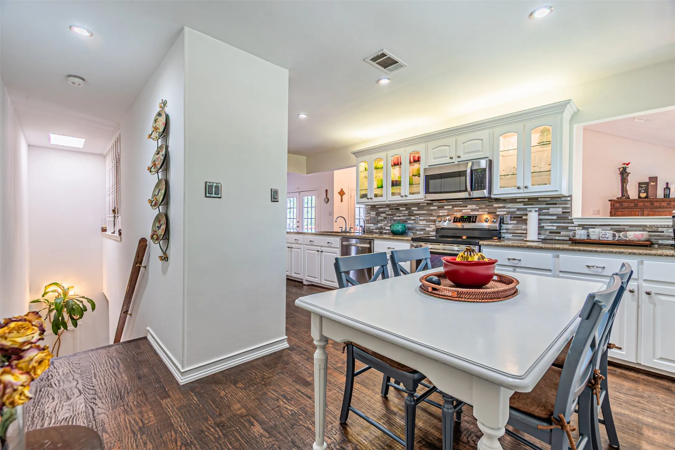 Kitchen with white cabinetry, stainless steel appliances, and a mosaic tile backsplash
