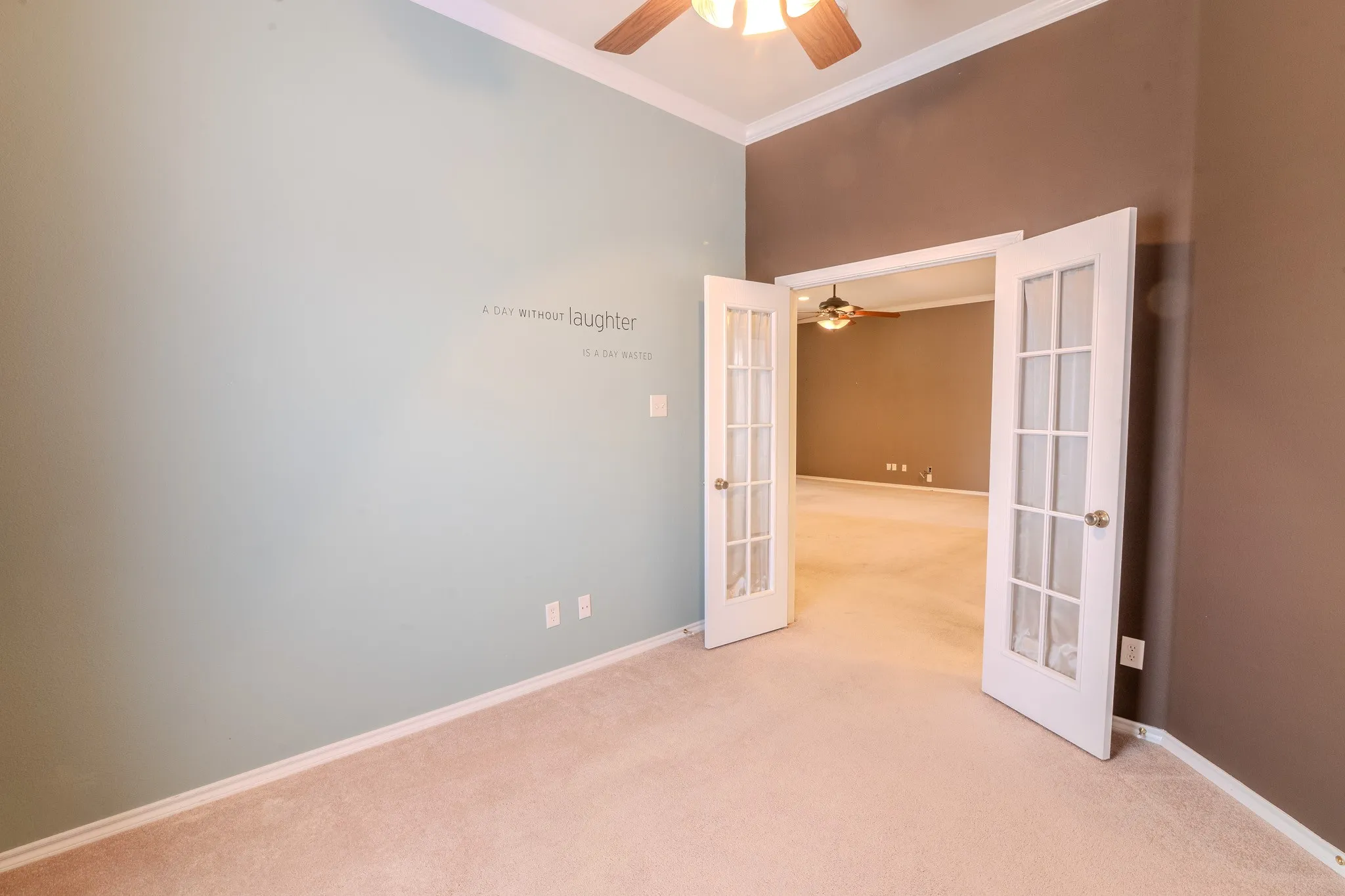 Room featuring French doors with glass panels, light-toned carpeting, two-tone wall paint, a ceiling fan, and white baseboards
