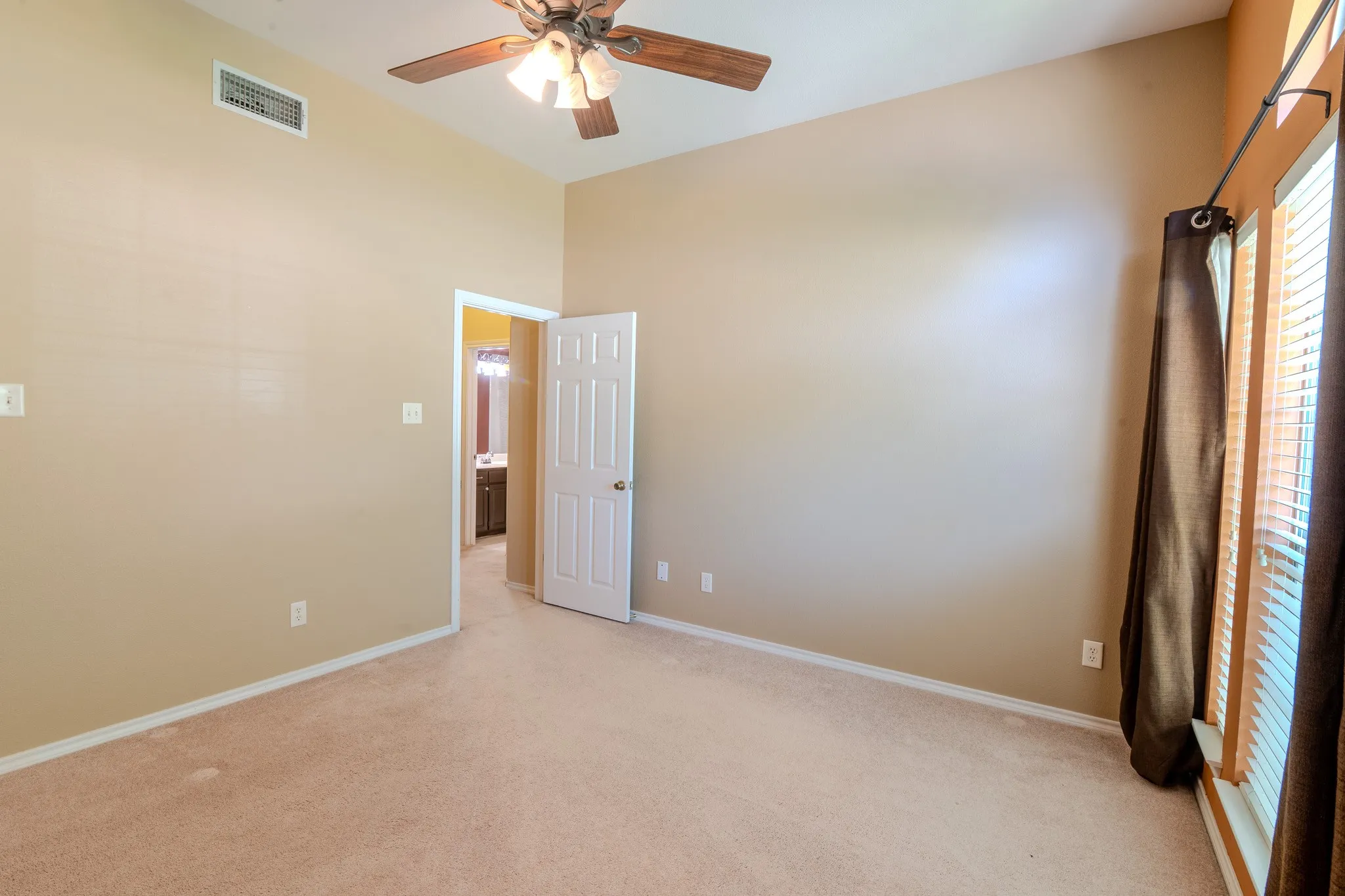 Carpeted room featuring a vaulted ceiling and a ceiling fan