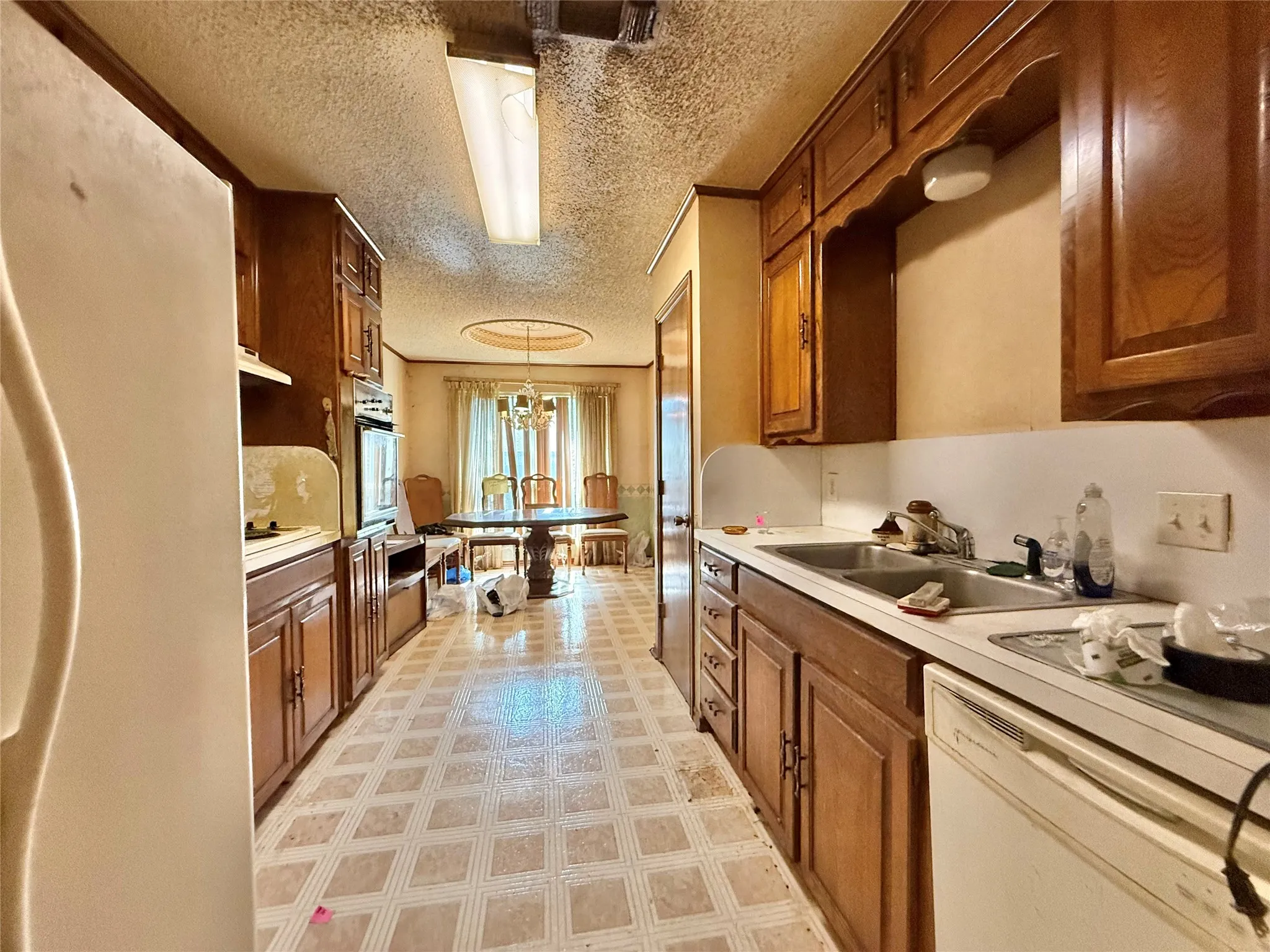 Galley kitchen featuring wood cabinetry and patterned flooring