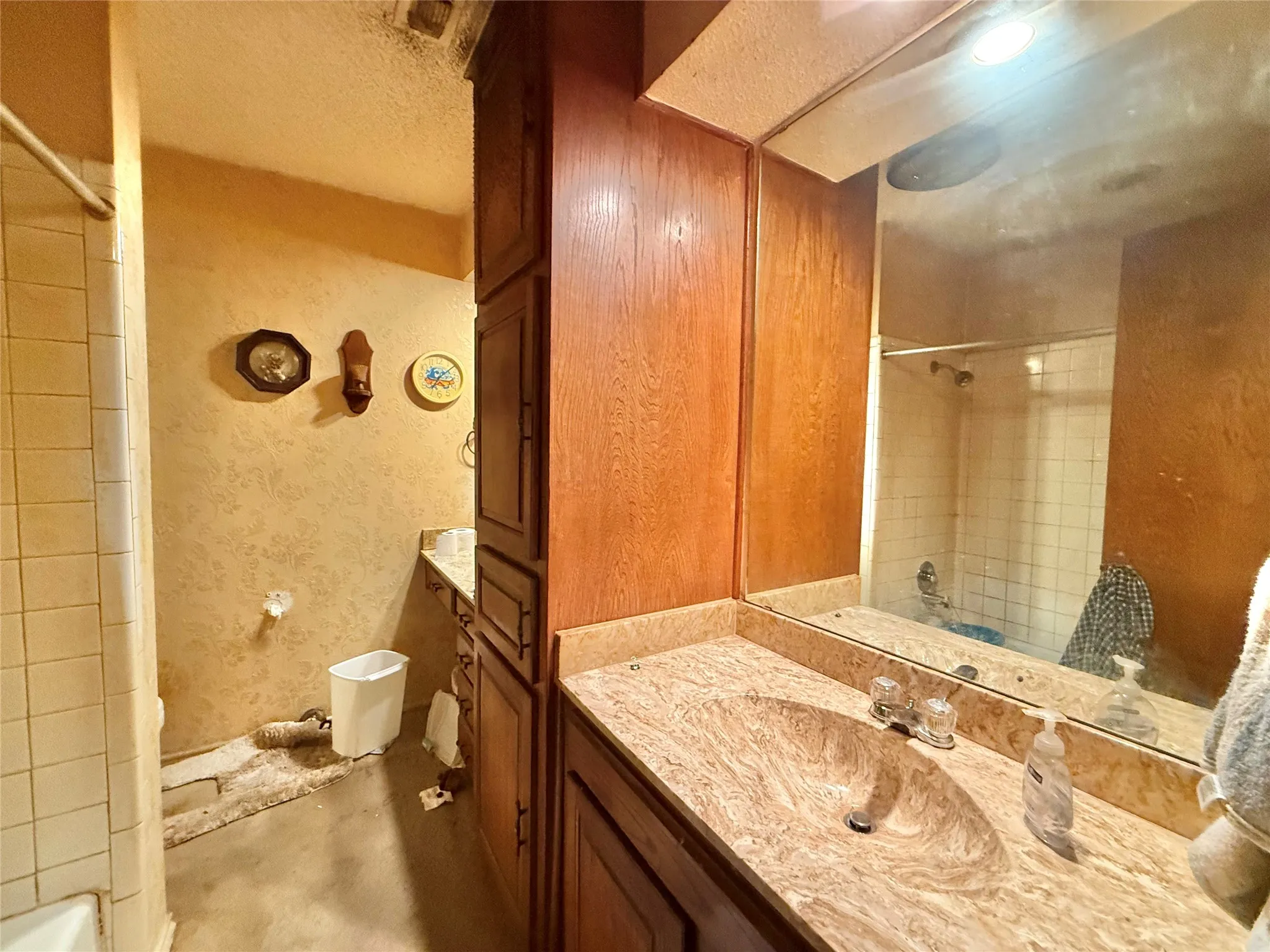 Bathroom featuring a vanity with an integrated sink and a large mirror