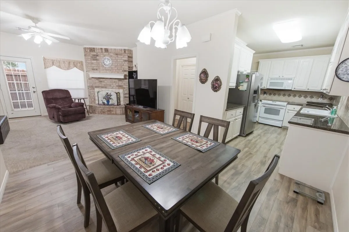 Open concept living area featuring wood-finish flooring in the dining and kitchen areas