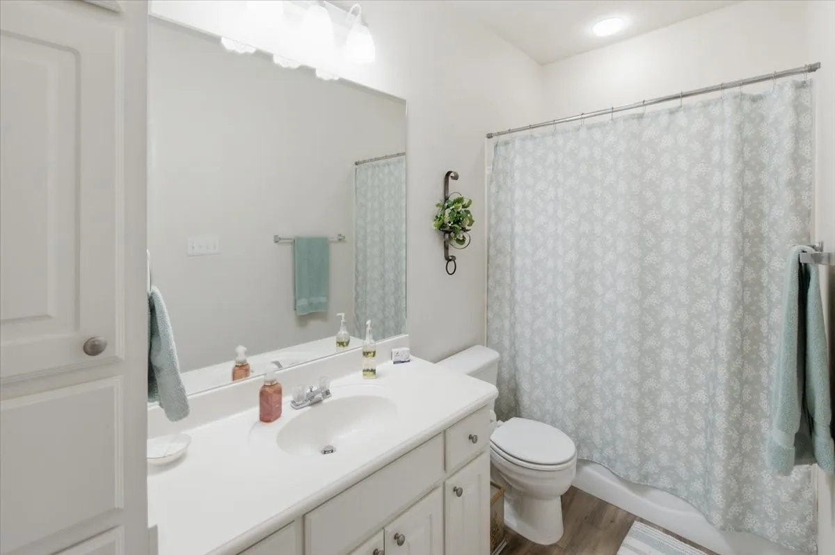 Bathroom featuring a single vanity with white cabinetry and a large wall mirror