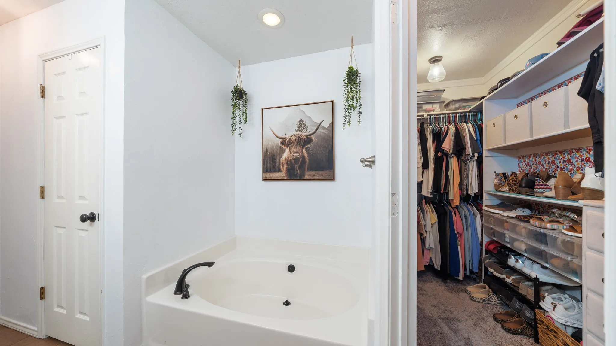 Primary Bathroom featuring garden tub and two closets