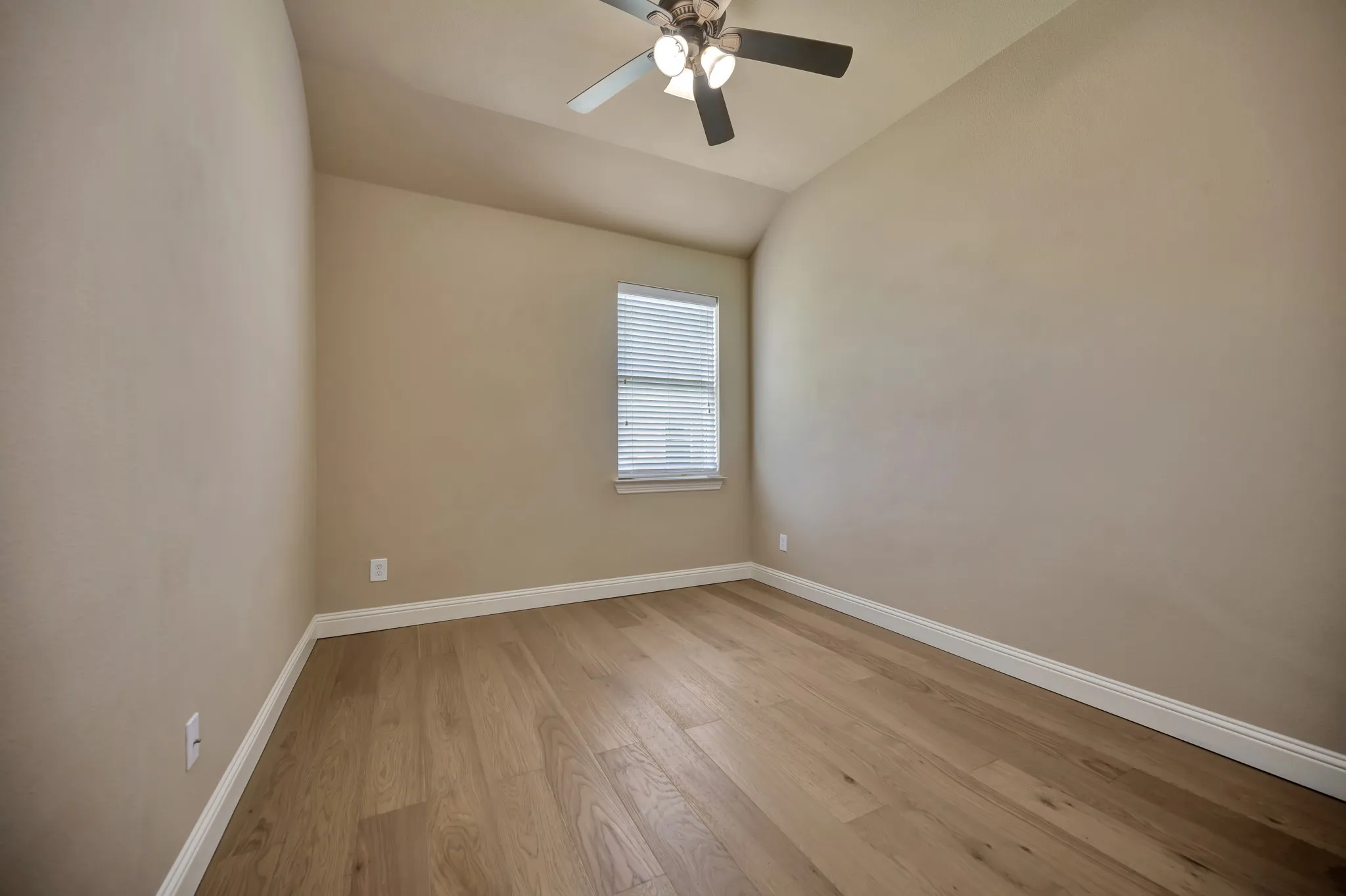 Room featuring wood-finish flooring, a contemporary ceiling fan with integrated lighting, a single window with blinds, and neutral-toned walls