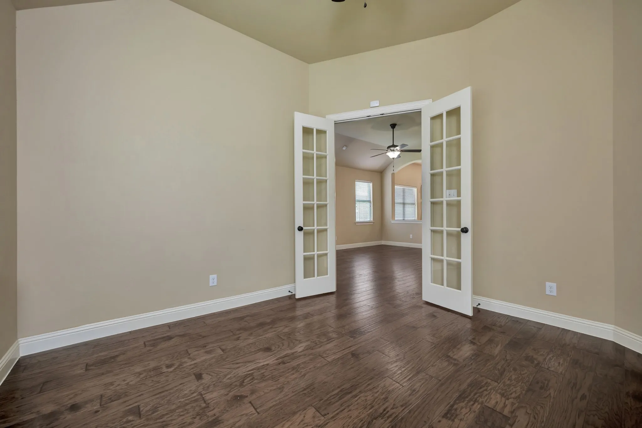 Room featuring wood-finish flooring, neutral wall tones, and white baseboards