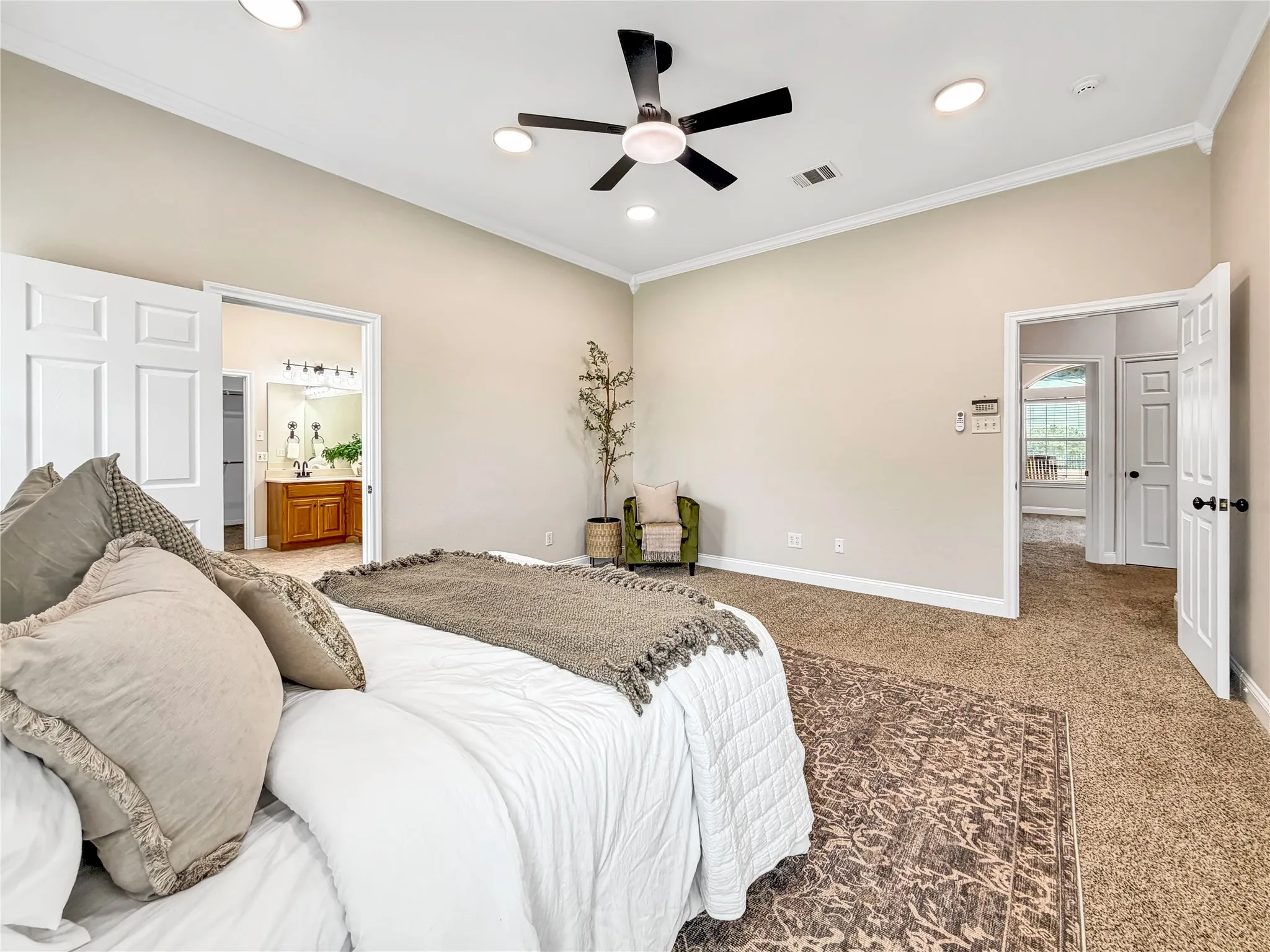 Carpeted bedroom with a vaulted ceiling and recessed lighting