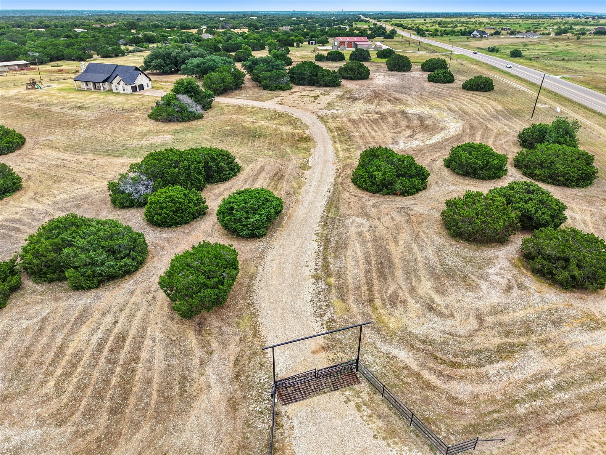Expansive rural acreage featuring a perimeter fence and gated entry