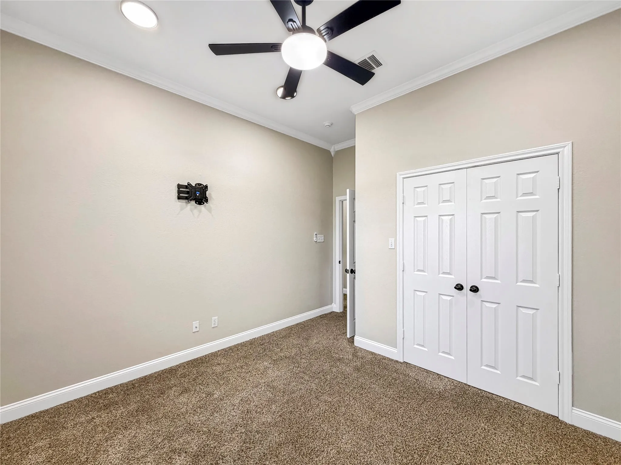 Room featuring crown molding, neutral wall color, and plush carpeting