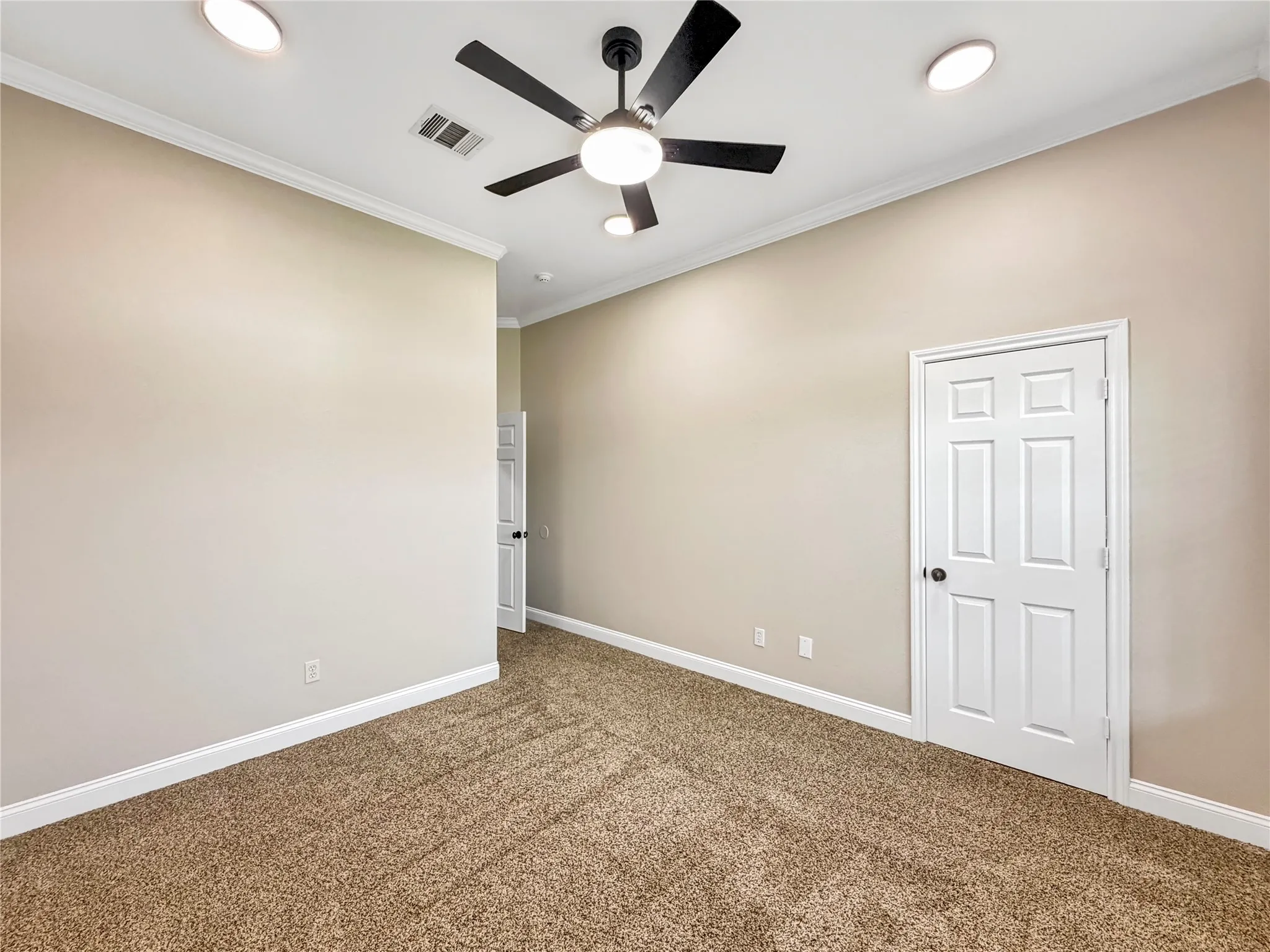 Neutral tone walls with crown molding and baseboards