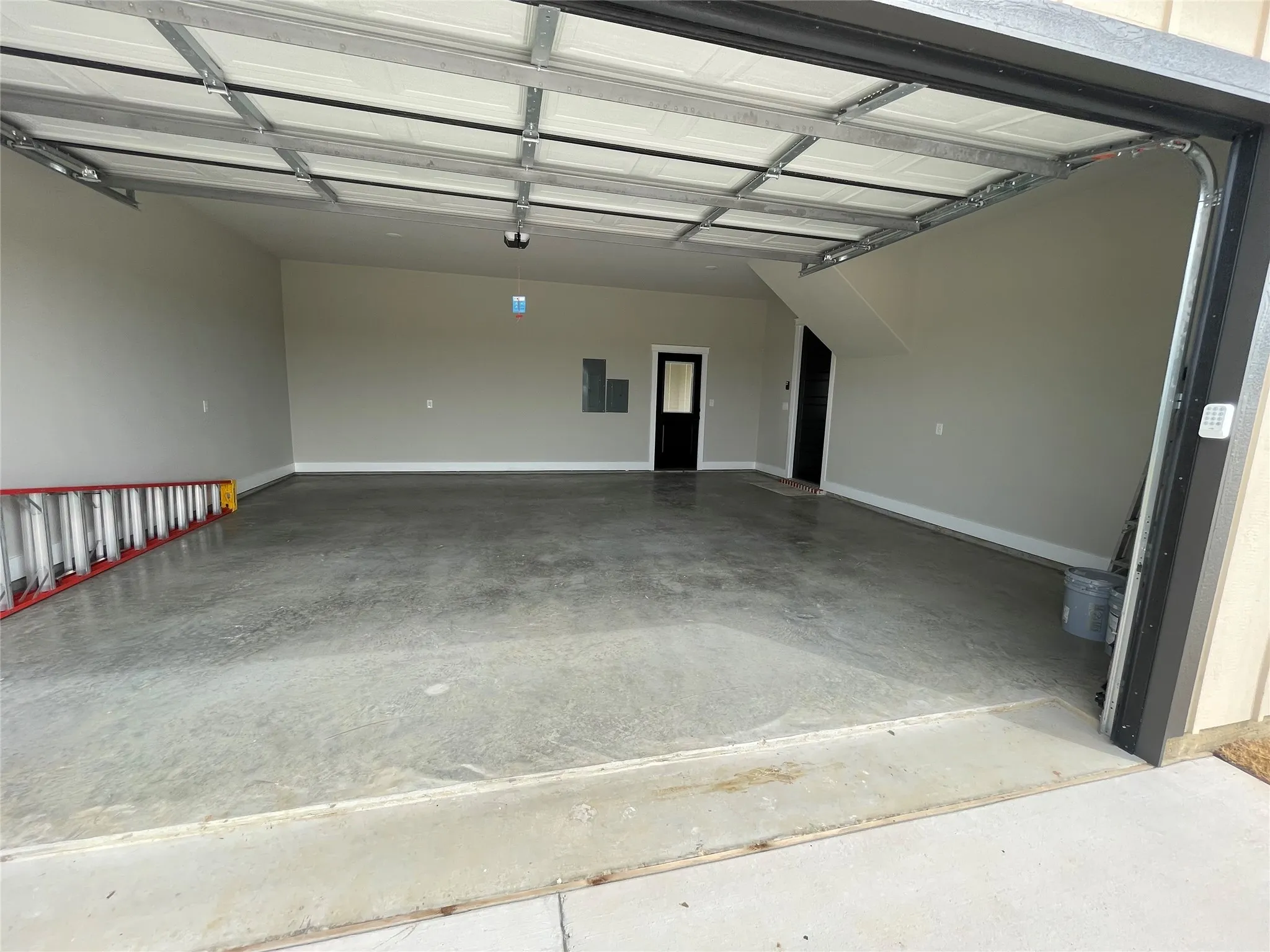 Spacious garage featuring a concrete floor, light gray painted walls, and white baseboards