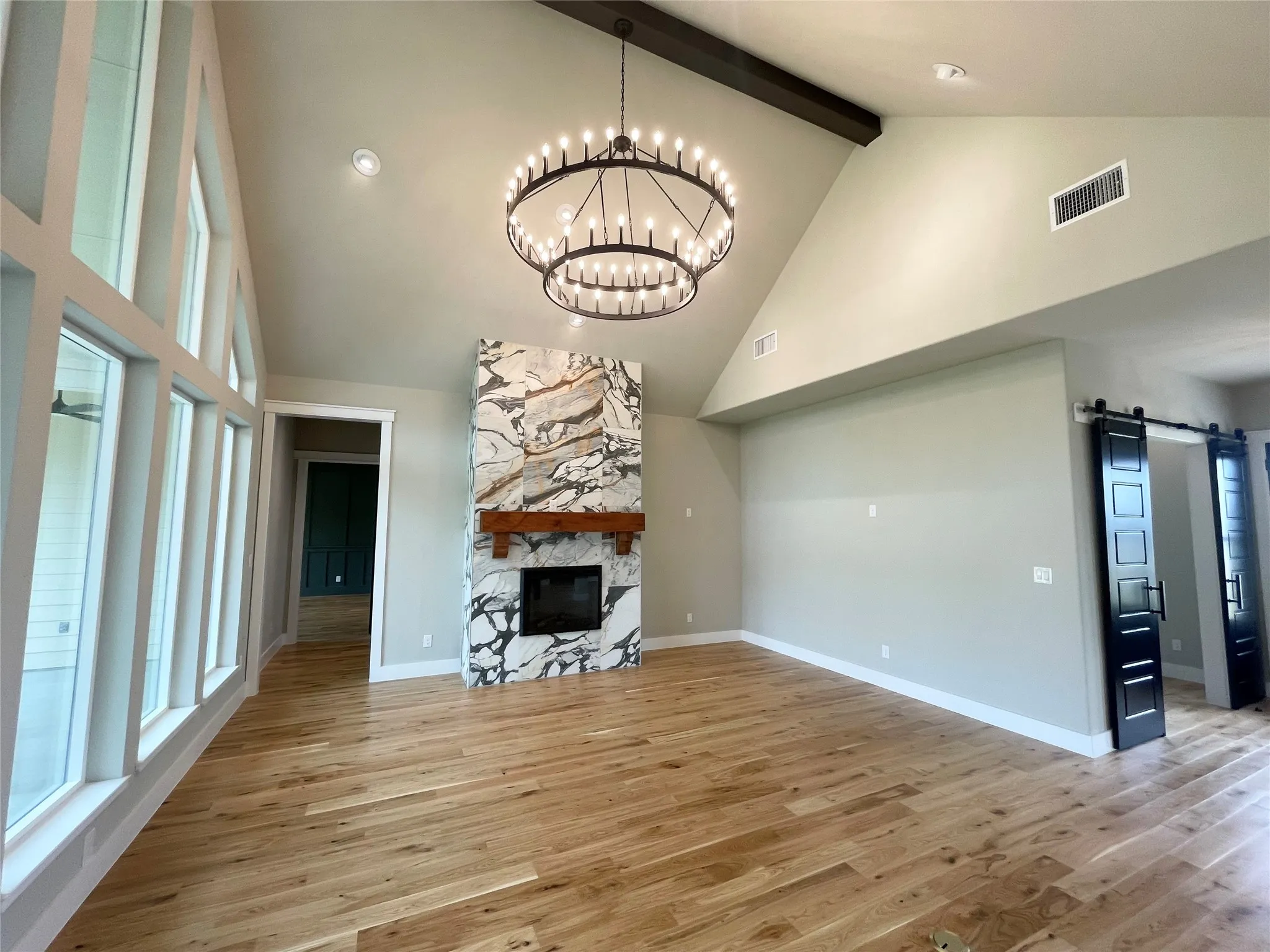 Vaulted ceilings with an exposed beam and a tiered chandelier
