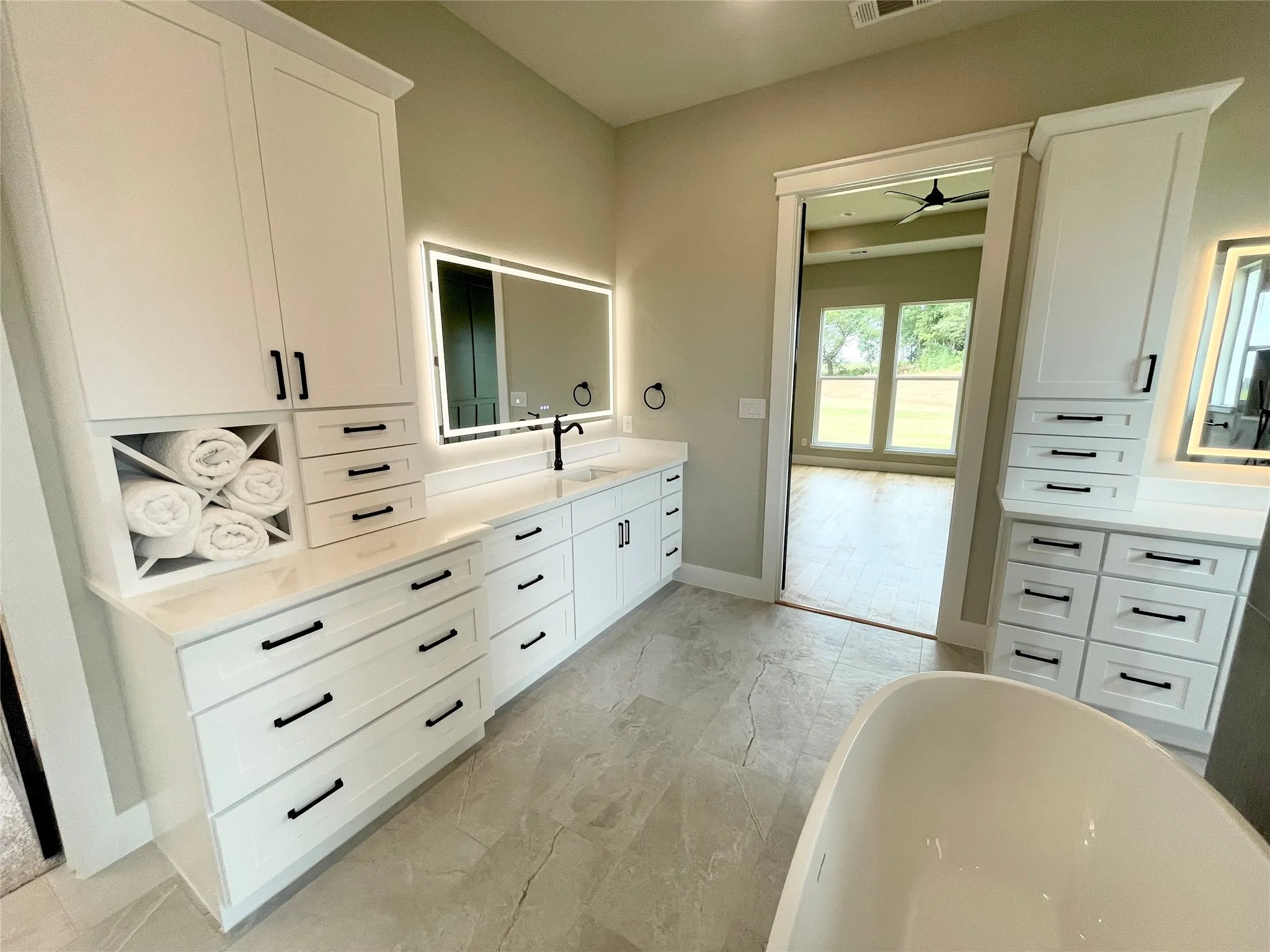 Bathroom vanity with white cabinetry and integrated towel storage