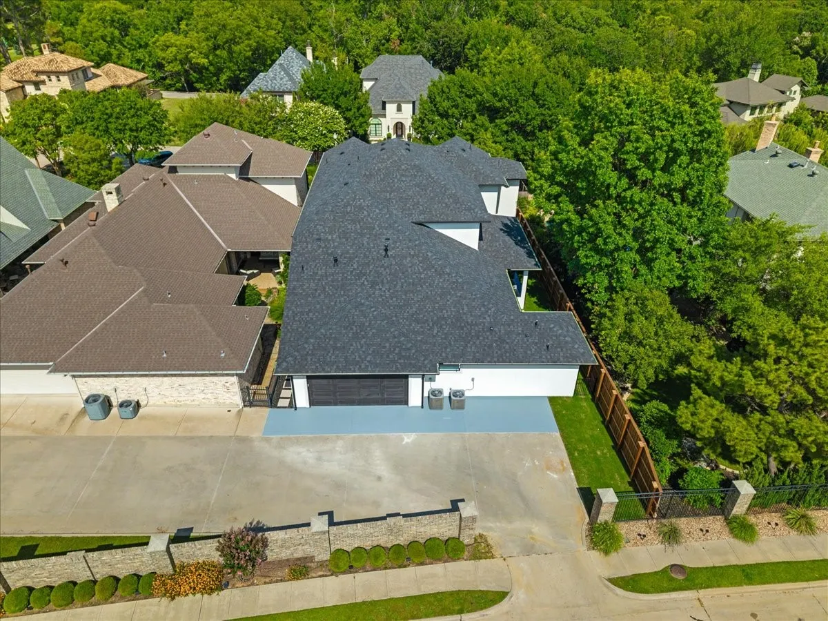 Contemporary two-story residence featuring a dark shingle roof, white exterior siding, and an attached two-car garage with a black door