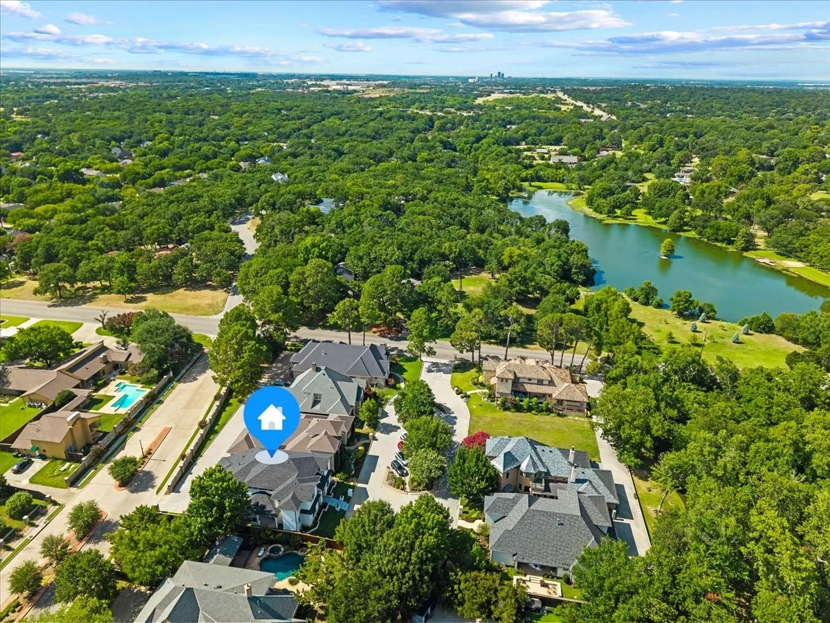 Aerial perspective of a verdant neighborhood showcasing a prominent body of water