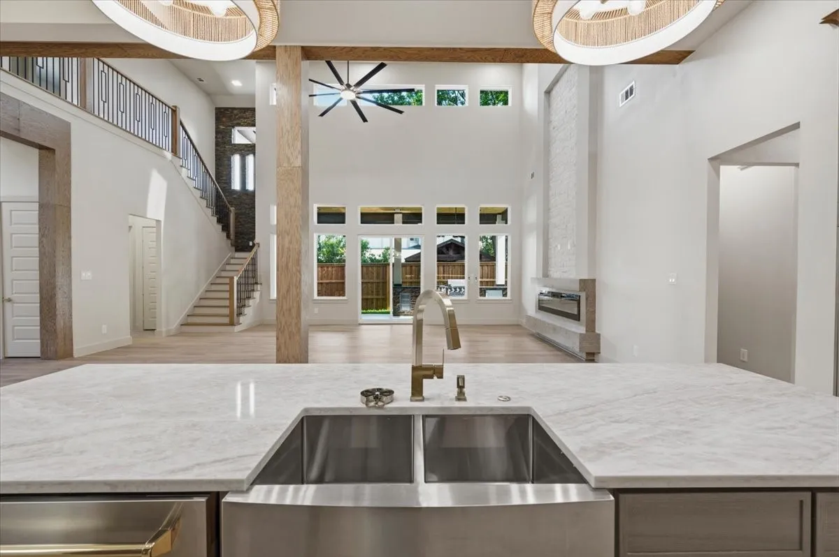 Expansive kitchen island featuring a farmhouse-style stainless steel sink and a contemporary faucet
