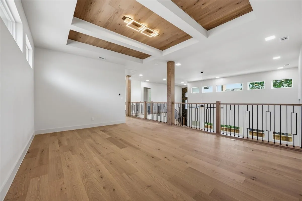 Expansive open space featuring a coffered wood-finish ceiling with a contemporary linear light fixture