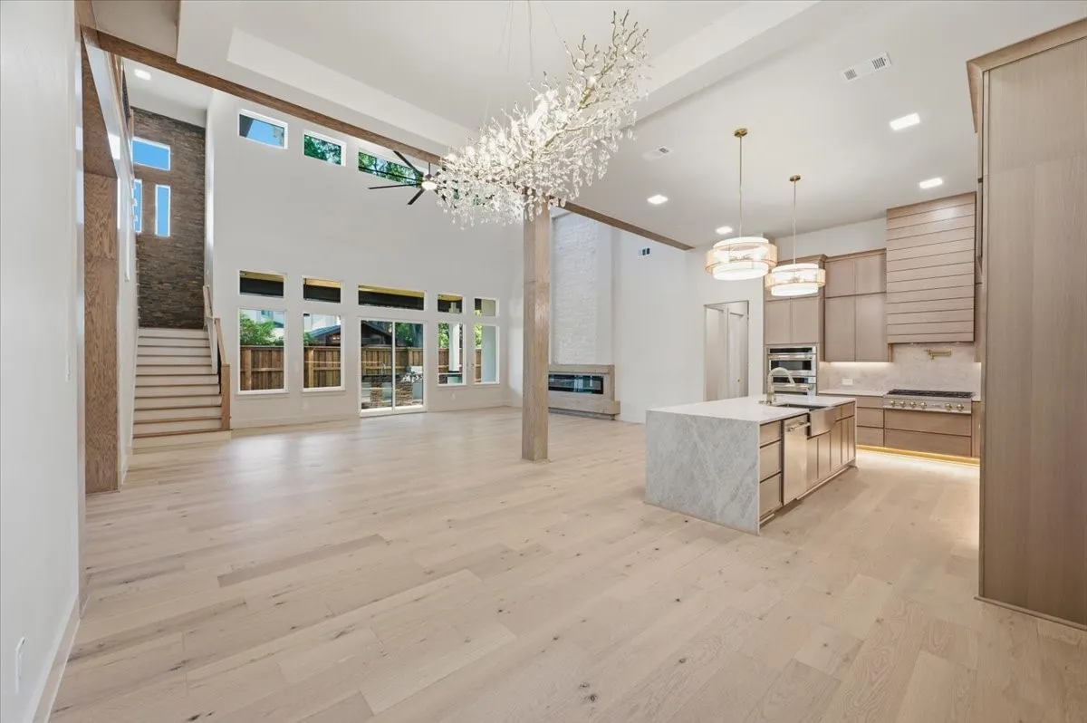 Expansive open-concept living space with light wood-finish flooring