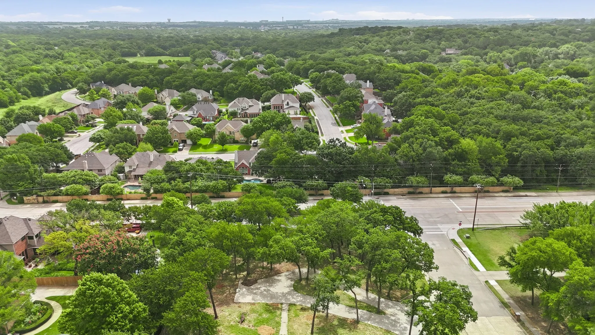 Aerial perspective showcasing a residential community surrounded by abundant mature trees