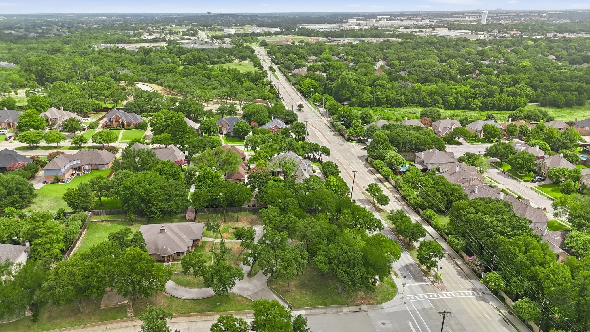 Aerial perspective showcasing a residential neighborhood with extensive tree coverage