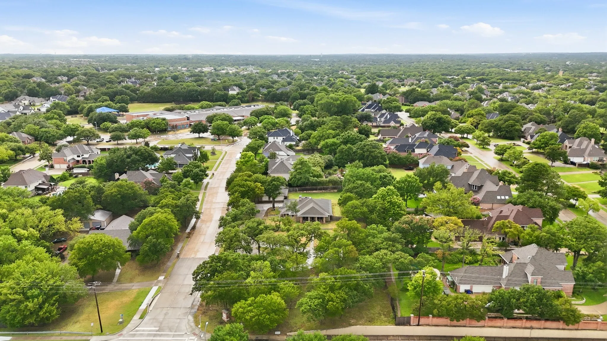 Residential area featuring mature trees, paved streets, and a variety of home architectural styles